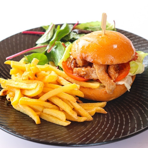 一盘鸡肉三明治配薯条和一小份沙拉。