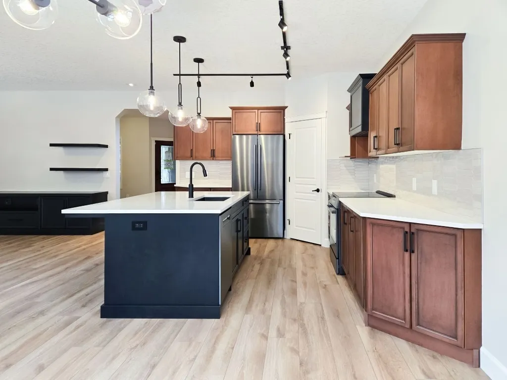 Image of Modern kitchen design with island, stainless steel appliances, and wooden cabinets by KHD Homes.