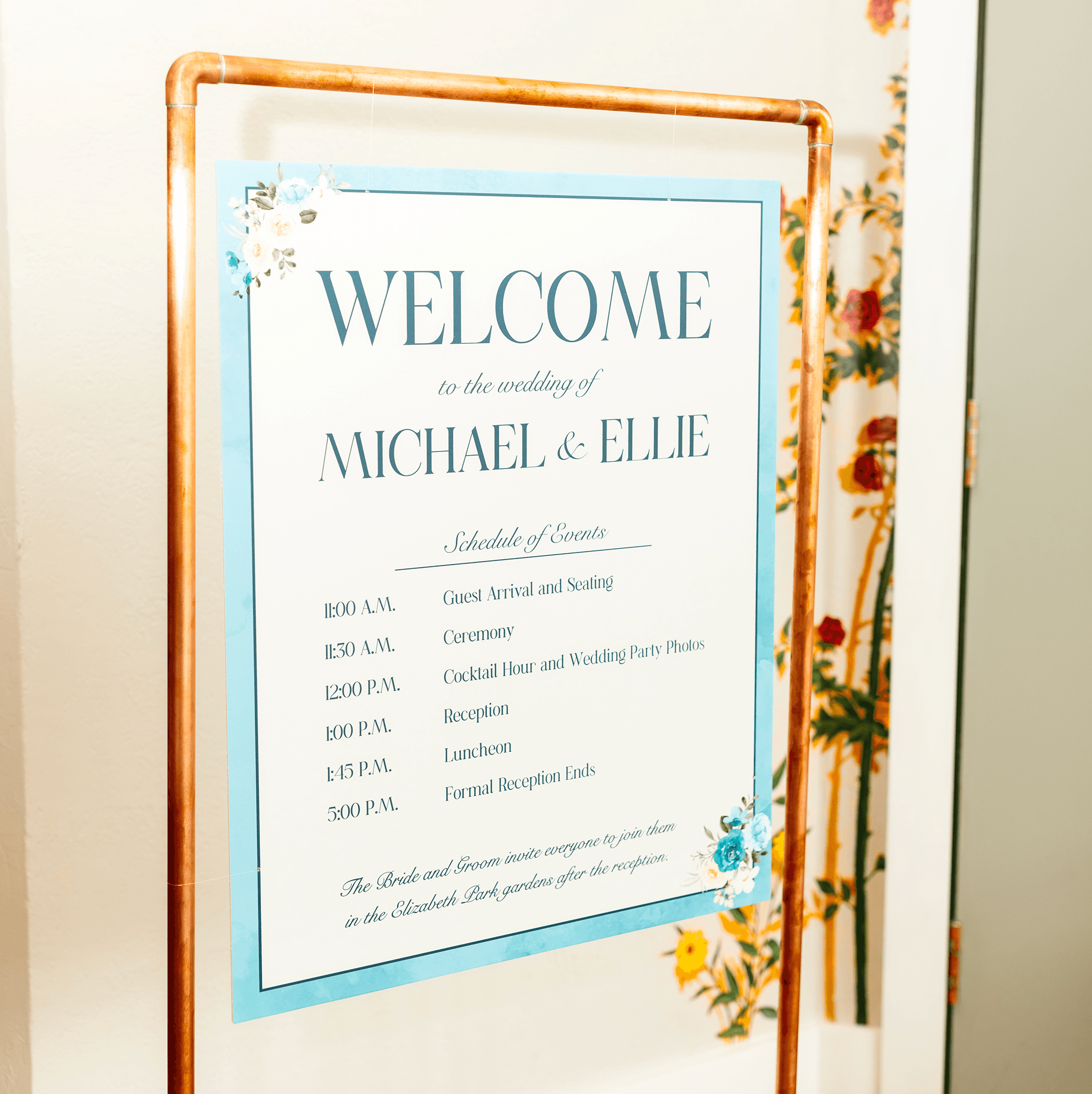 Photo of a wedding welcome sign and desgined in an elegat style with painted roses and an elegant serif typography. Designed by Will Lefkovich