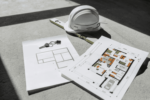 안전모와 설계도로 표현된 건축 안전 철학, 시공 현장 안전 관리