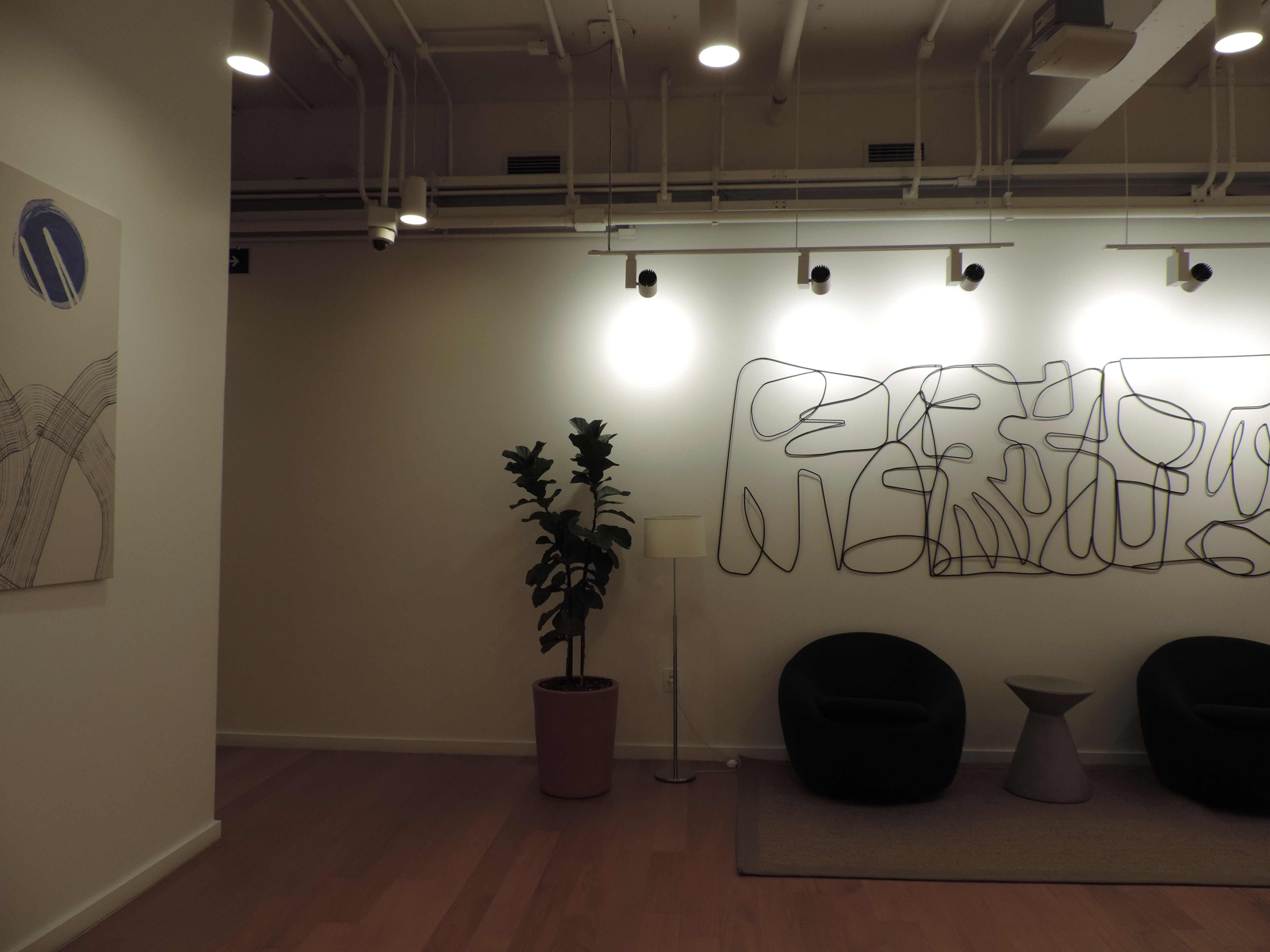 Beige interior with natural stone walls, sunlight, and geometric shadows over a calm water pool.