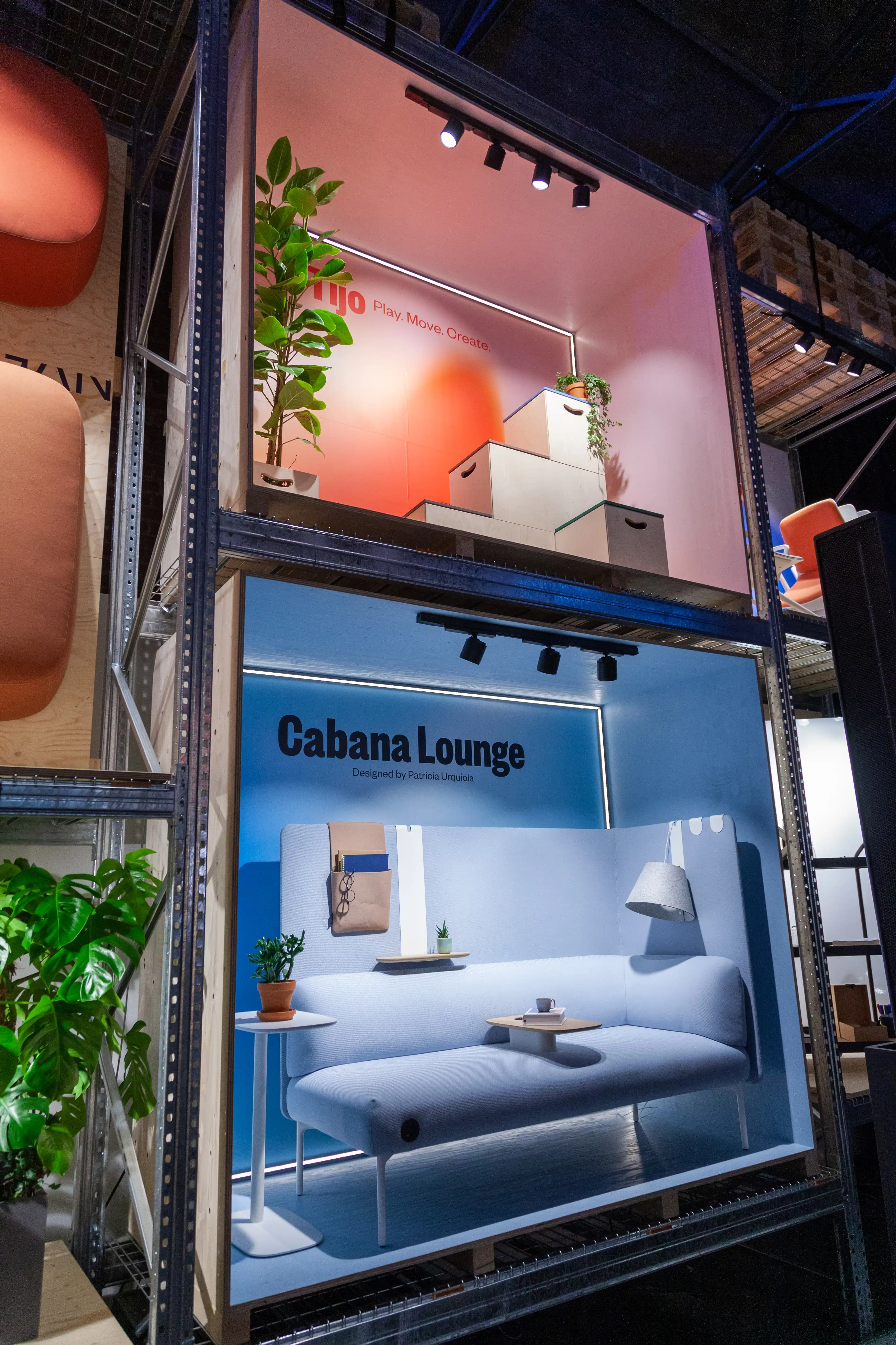 Stacked display boxes at the Haworth booth showing the pale blue Cabana Lounge sofa and a coral product scene above.