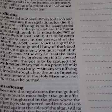 Close-up of open book with text and blank lines.