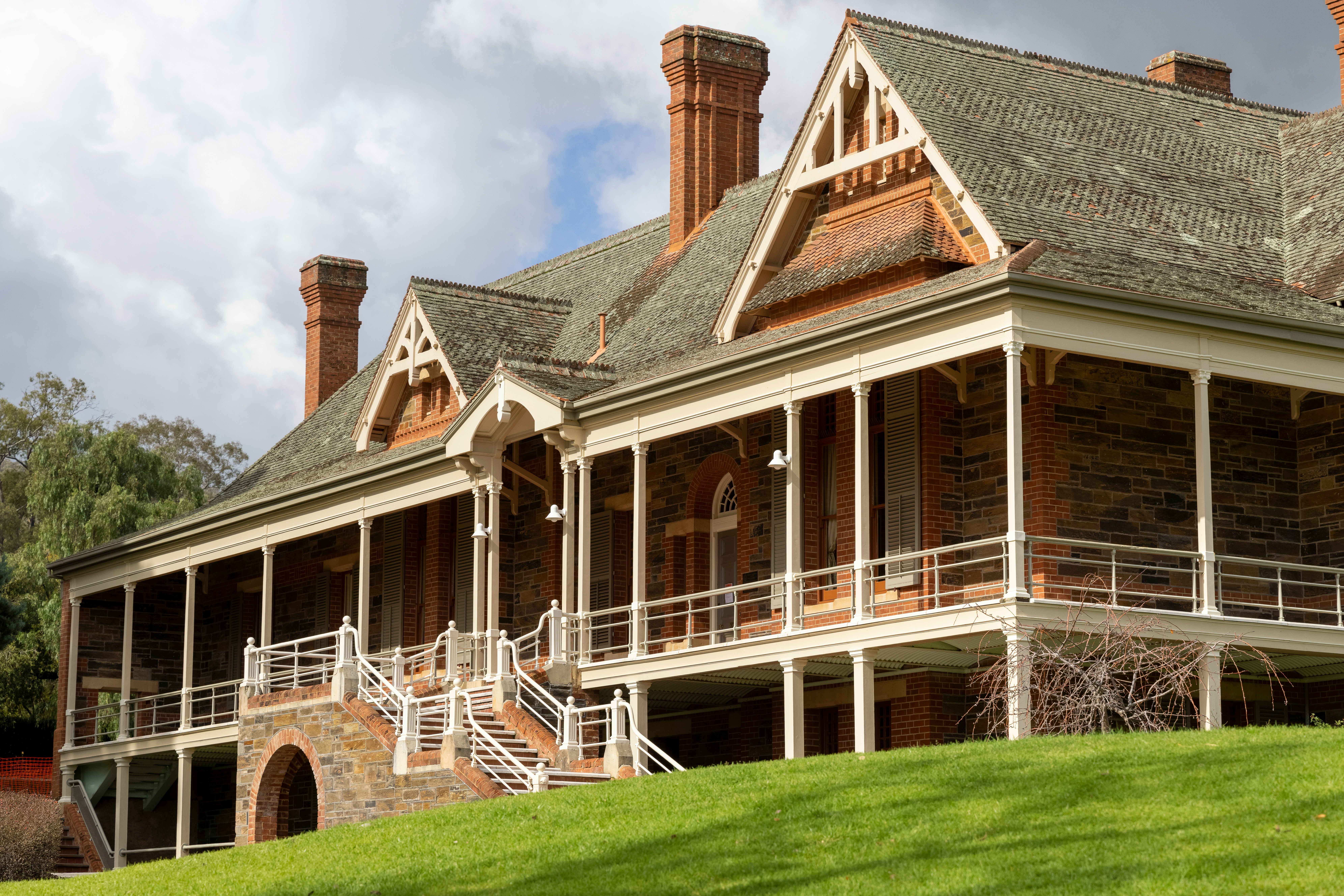 a large brick house with a green lawn