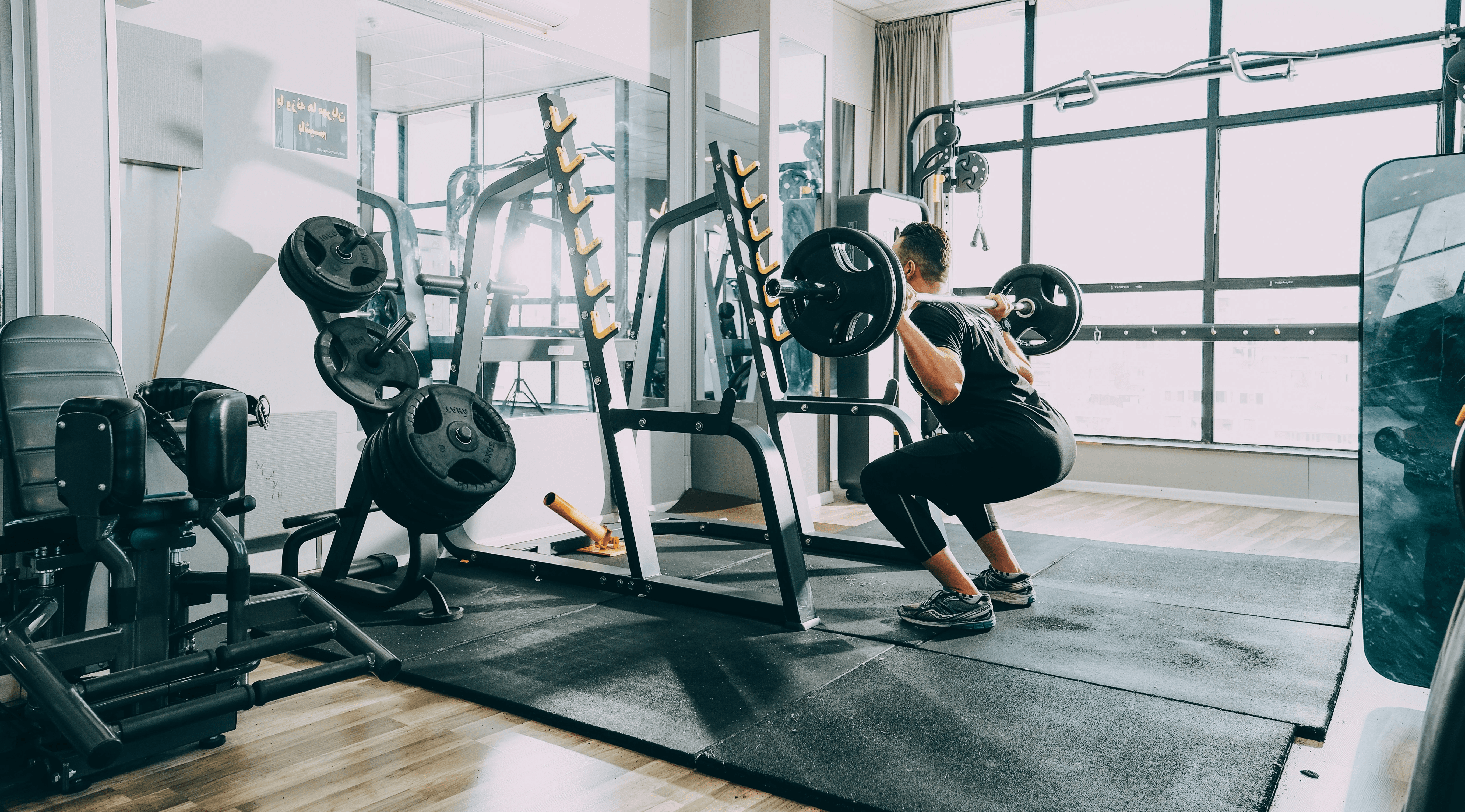 woman in black shirt and blue denim jeans sitting on black exercise equipment