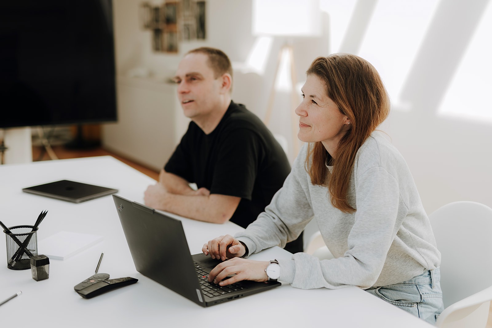 Zwei Personen im Gespräch auf einer Dachterrasse mit Stadtblick – steht für offene Zusammenarbeit und Austausch im mercury.ai Team