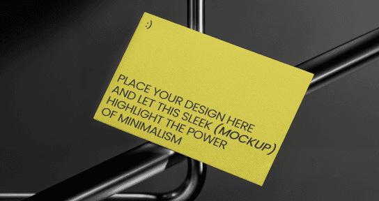 A minimalist yellow business card mockup resting against a sleek, black metallic wire frame. The card features placeholder text about minimalist design and a small smiley face icon in the top corner, set against a dark, moody background with soft studio lighting.