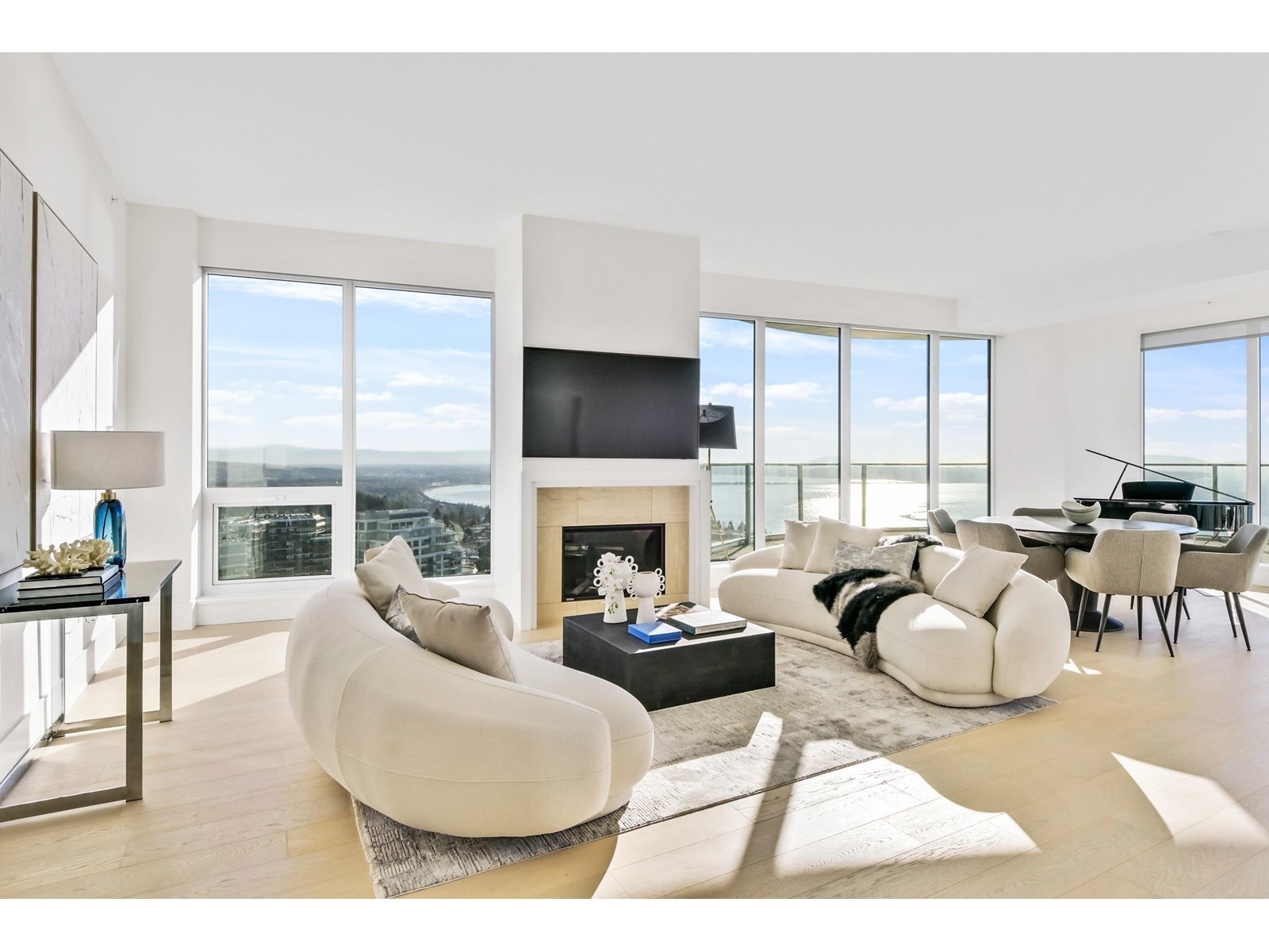 Bright, modern living room with large windows, a fireplace, and stylish furniture in a minimalist design.