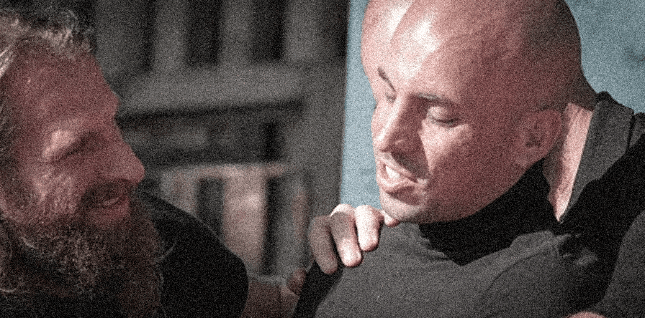 two people in a workspace working on their laptops 