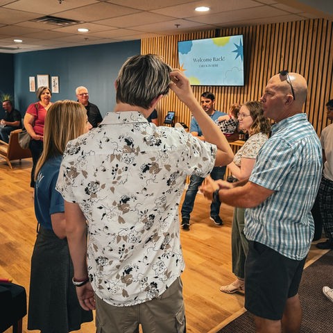 New Hope Church volunteer greeting guests during worship
