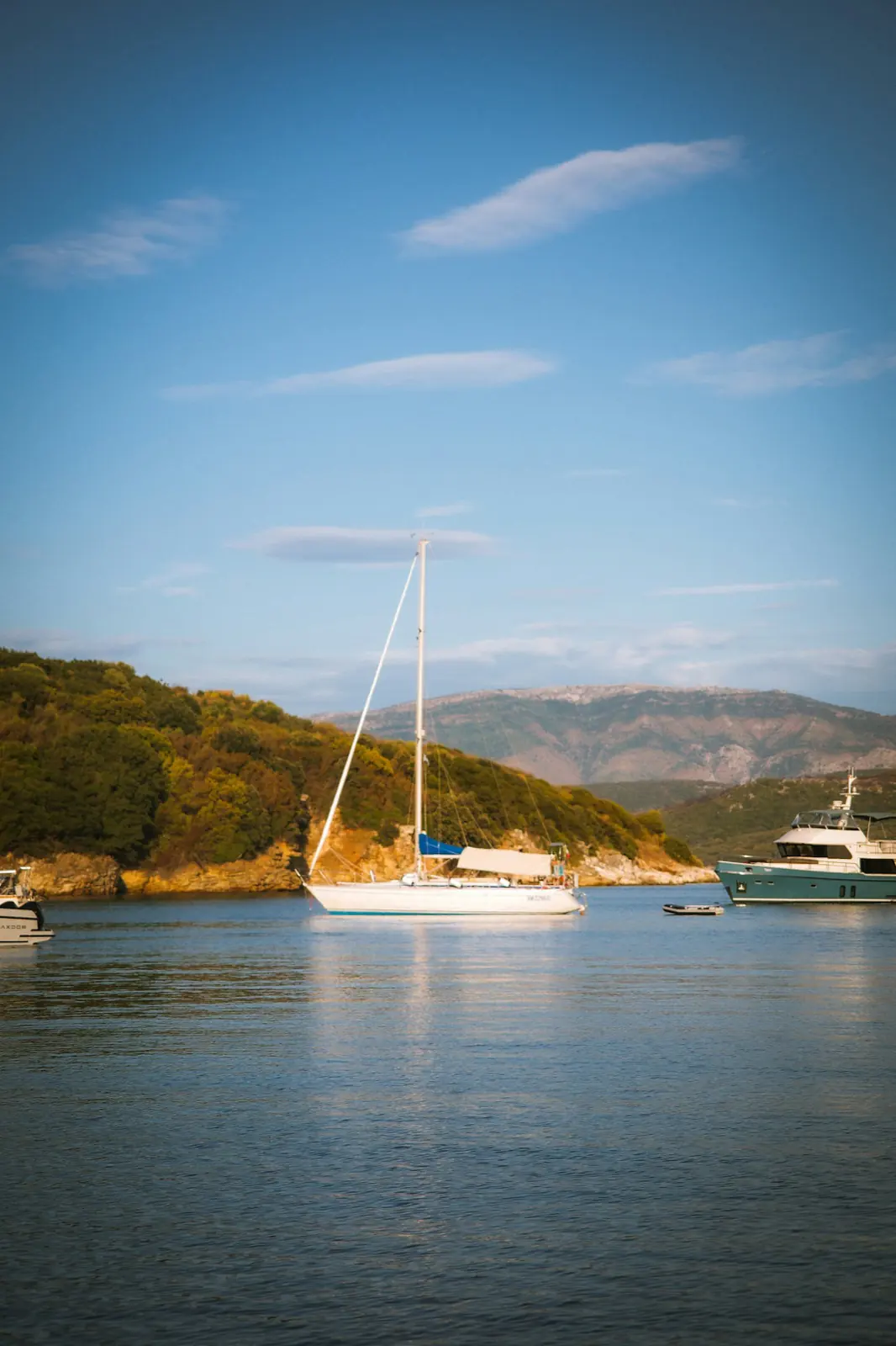 Voilier et yacht au mouillage dans une baie calme, à Corfou