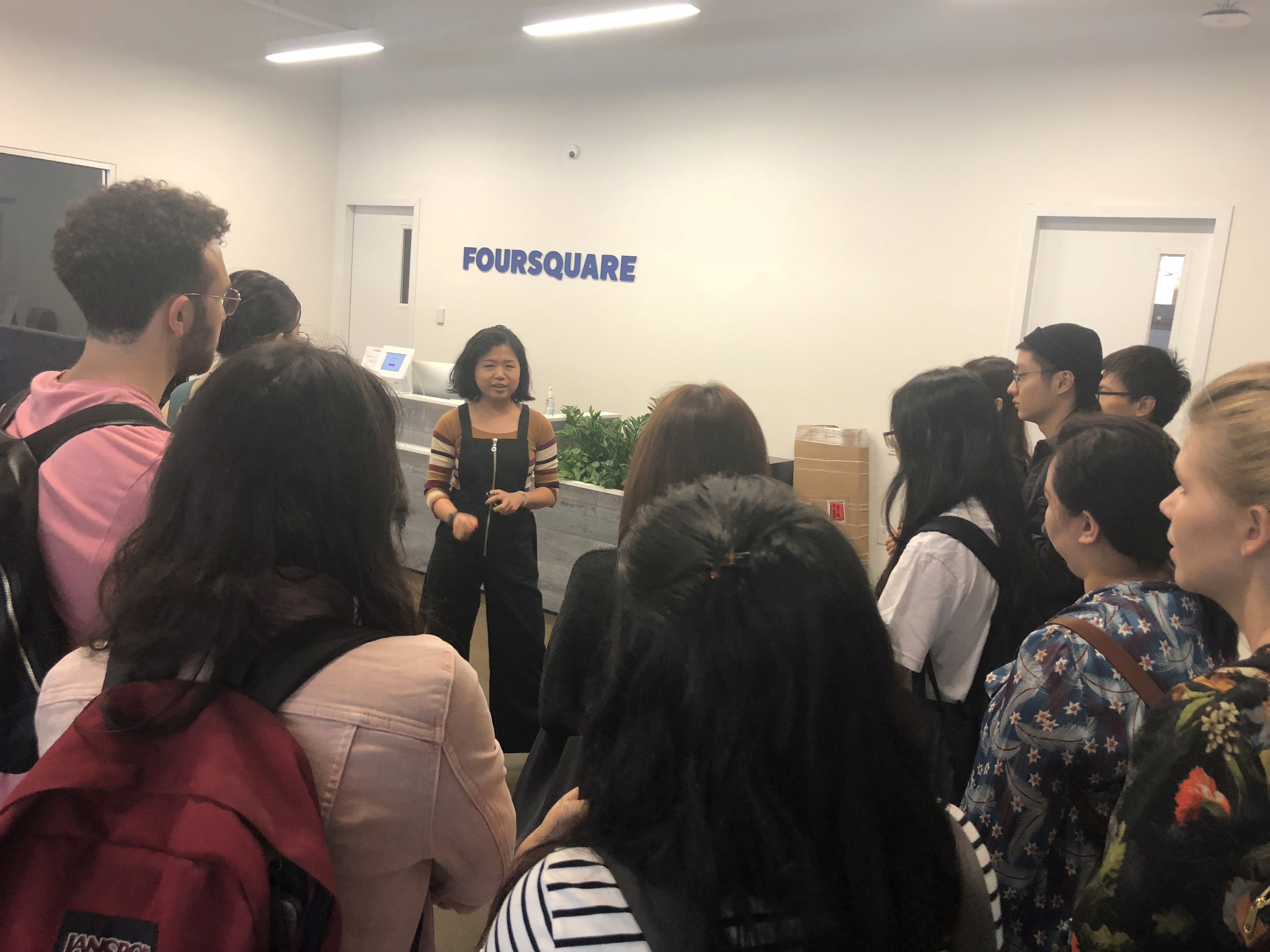 A photo of a group of people chatting in an office.