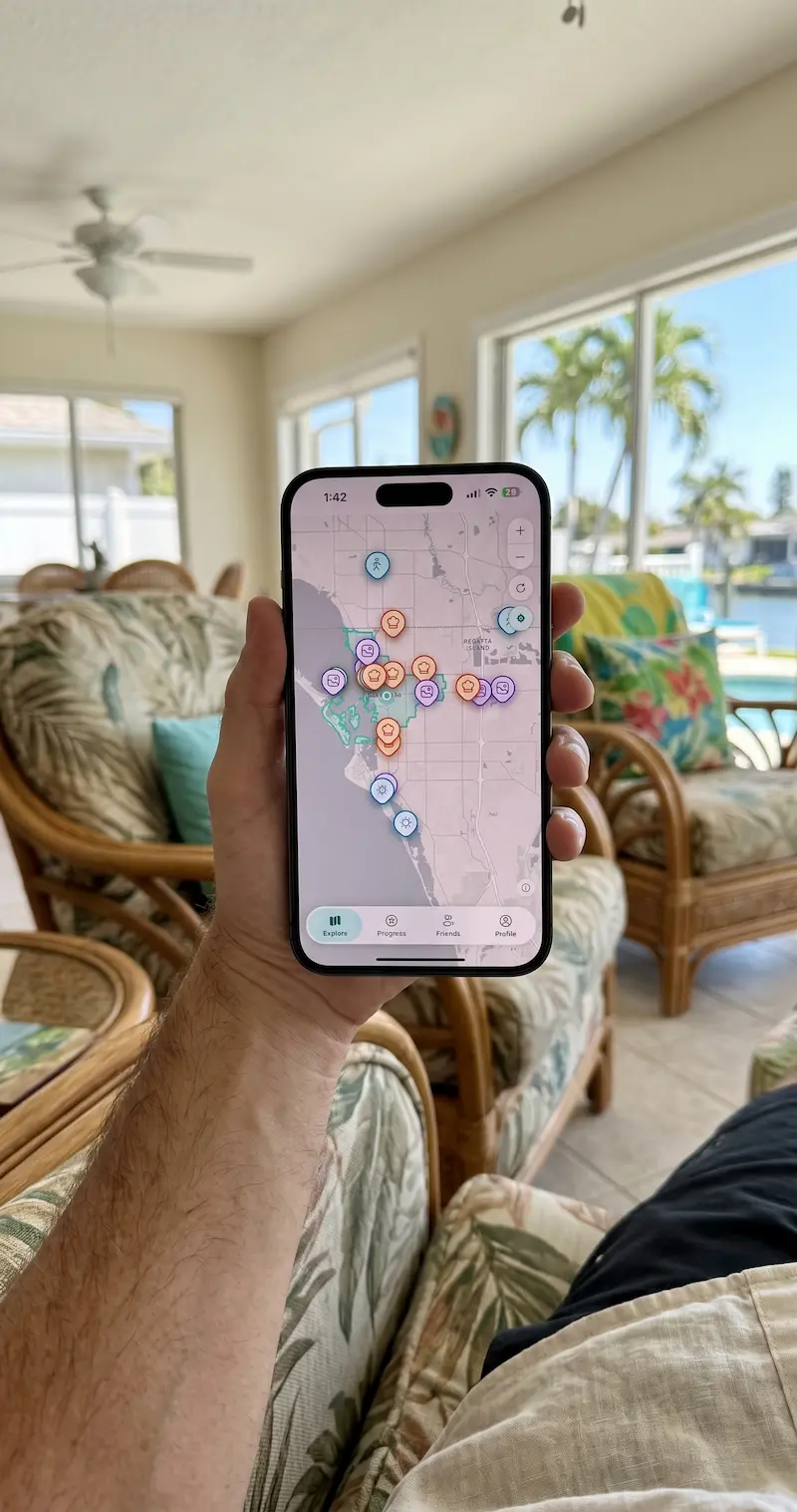 A person holds a smartphone displaying a colorful map with various pins, seated, suggesting vacation planning with Your Bucket List Company.