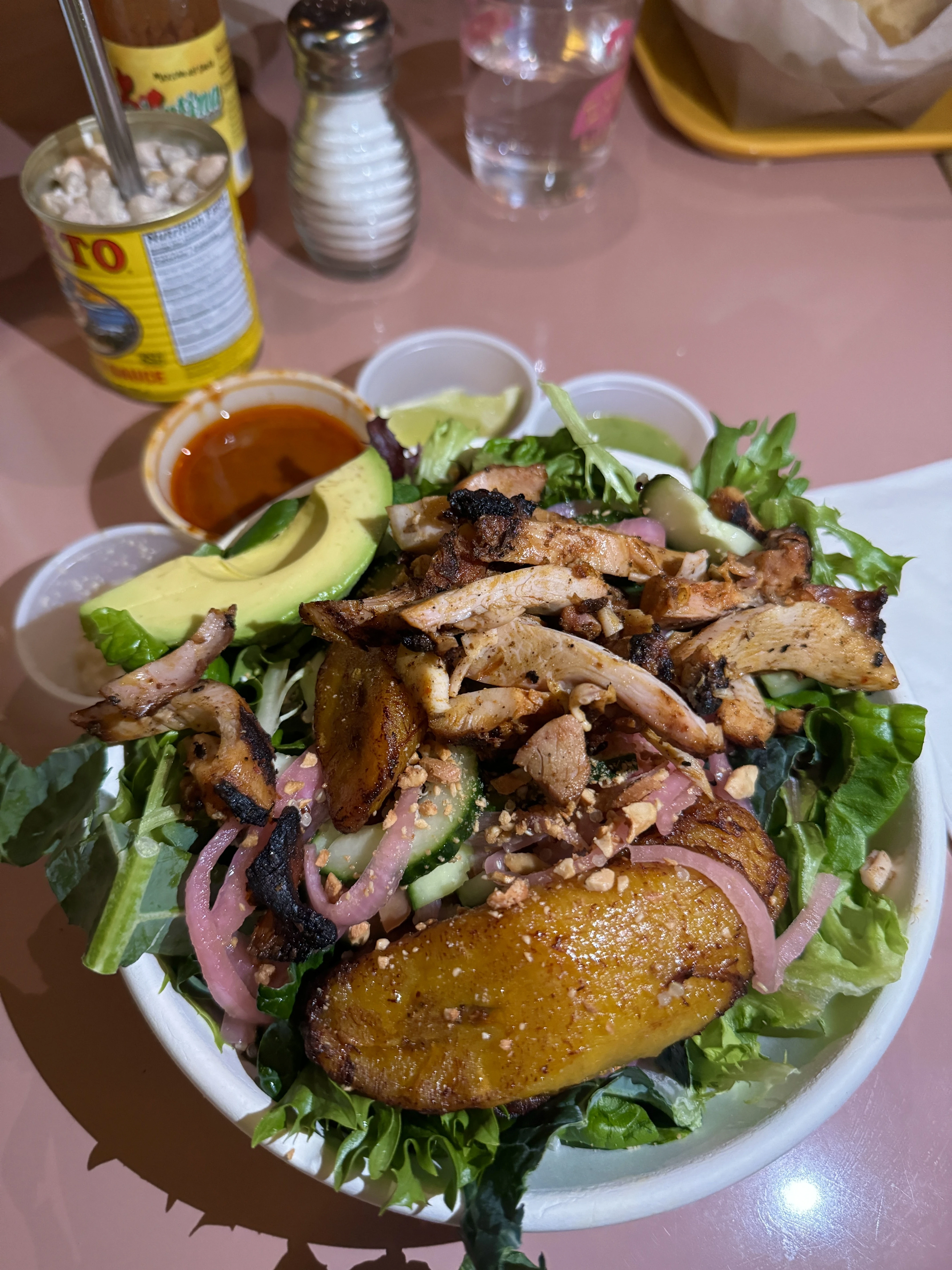 Equeleto salad add chicken, with quinoa, plantains, avocado, cucumber, pickled onions, toasted cashews, and a catalina dressing in a bowl at a restaurant in Raleigh, NC