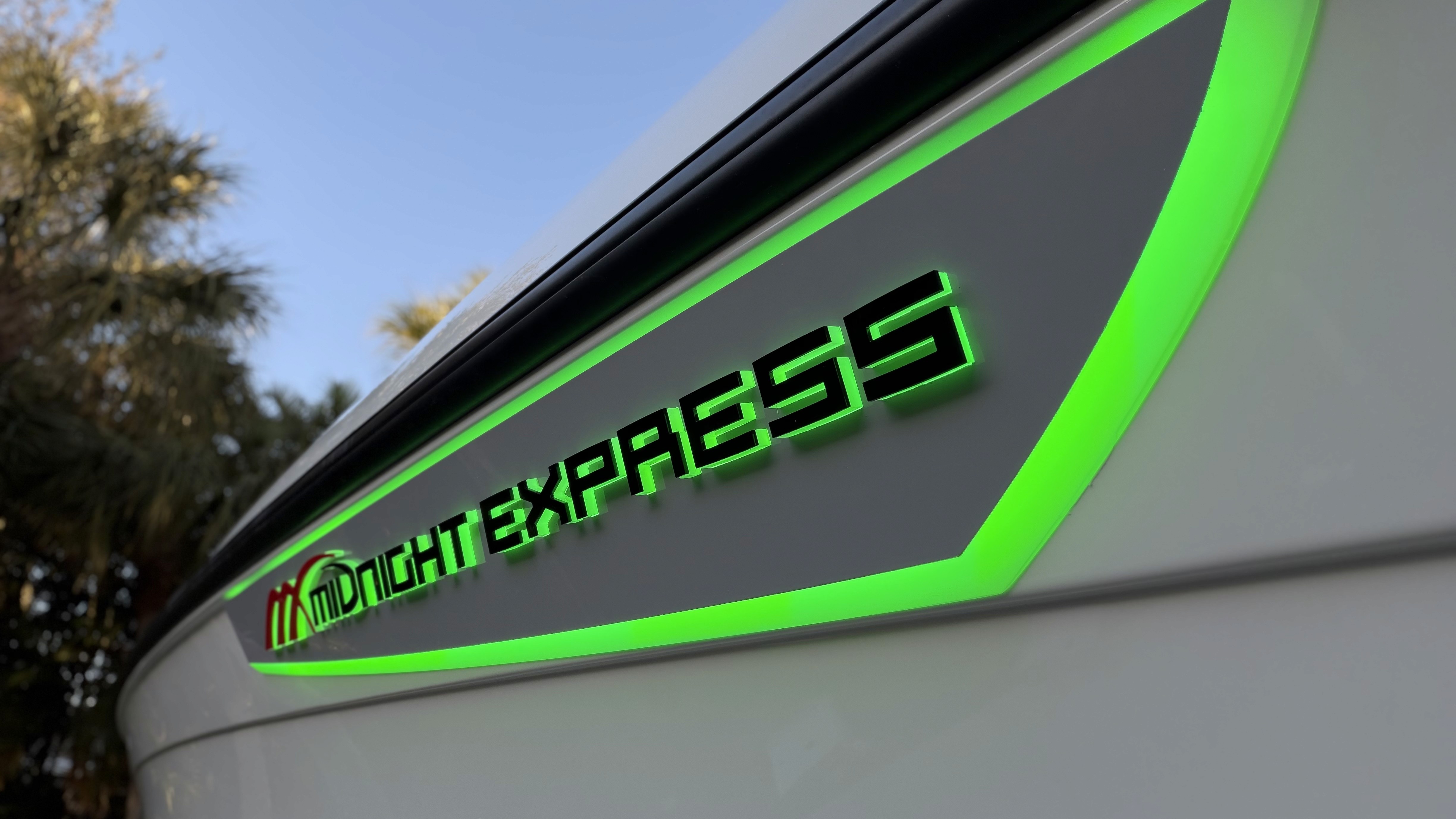 Custom LED illuminated green graphics on Midnight Express boat hull