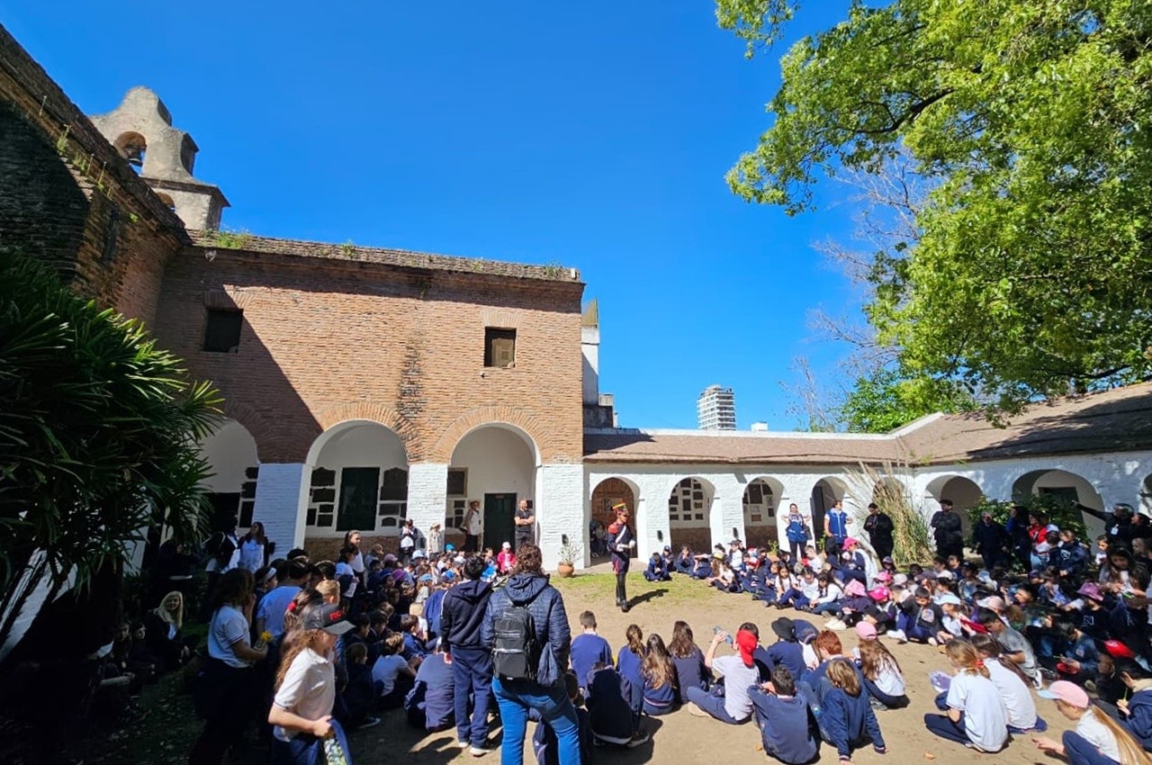 Niños reunidos en el patio de un edificio histórico durante una actividad.