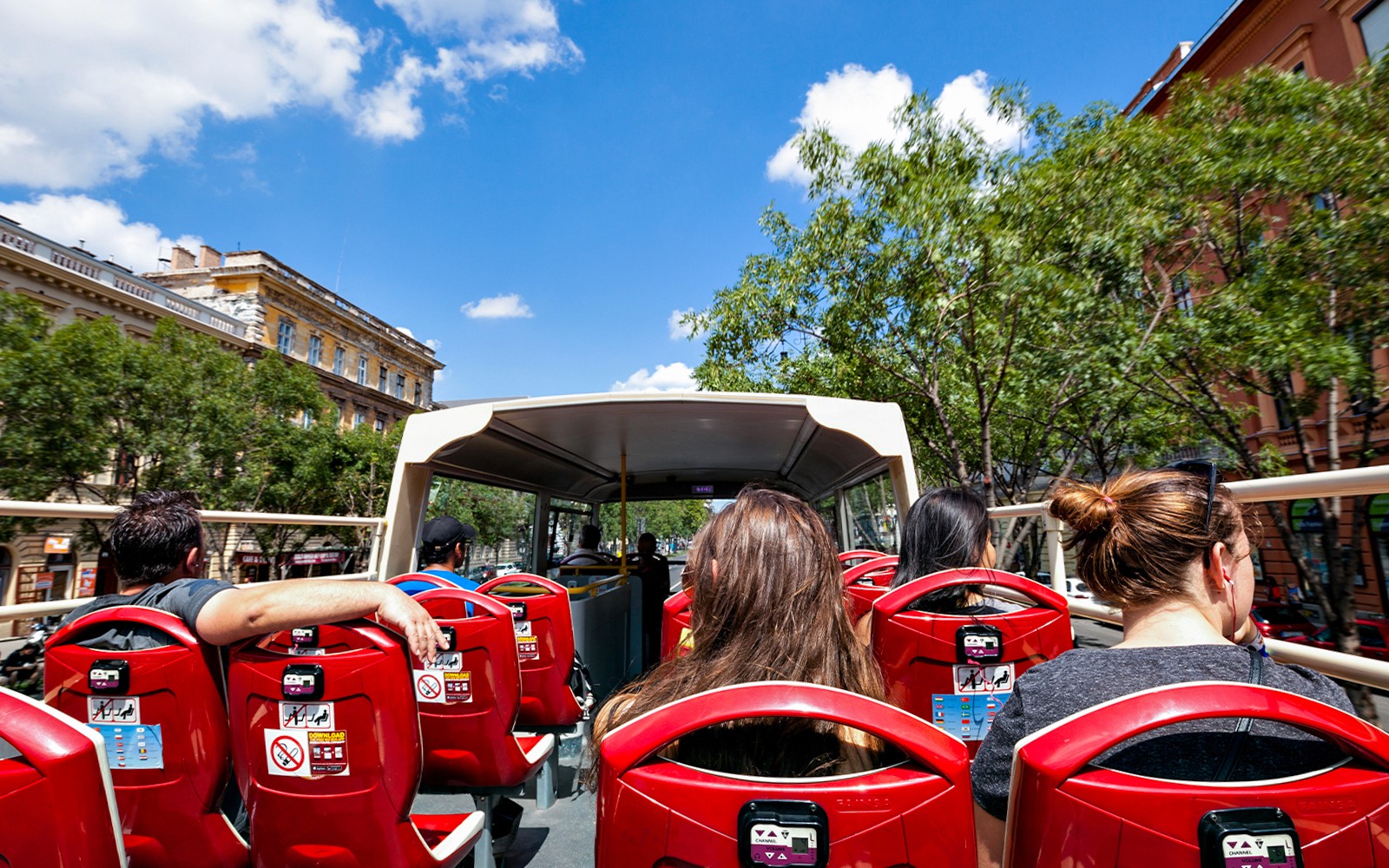 Passengers on Budapest hop-on hop-off bus tour with city landmarks in view