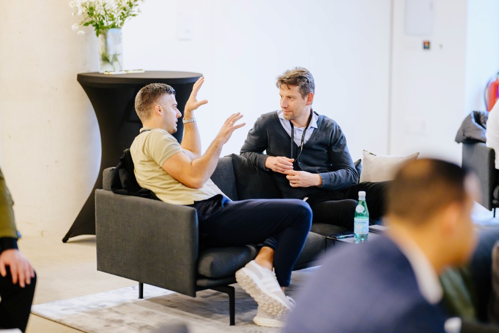 Intense one-on-one conversation at an automotive event – a lounge setting for exchanging ideas on product strategy or brand experience.