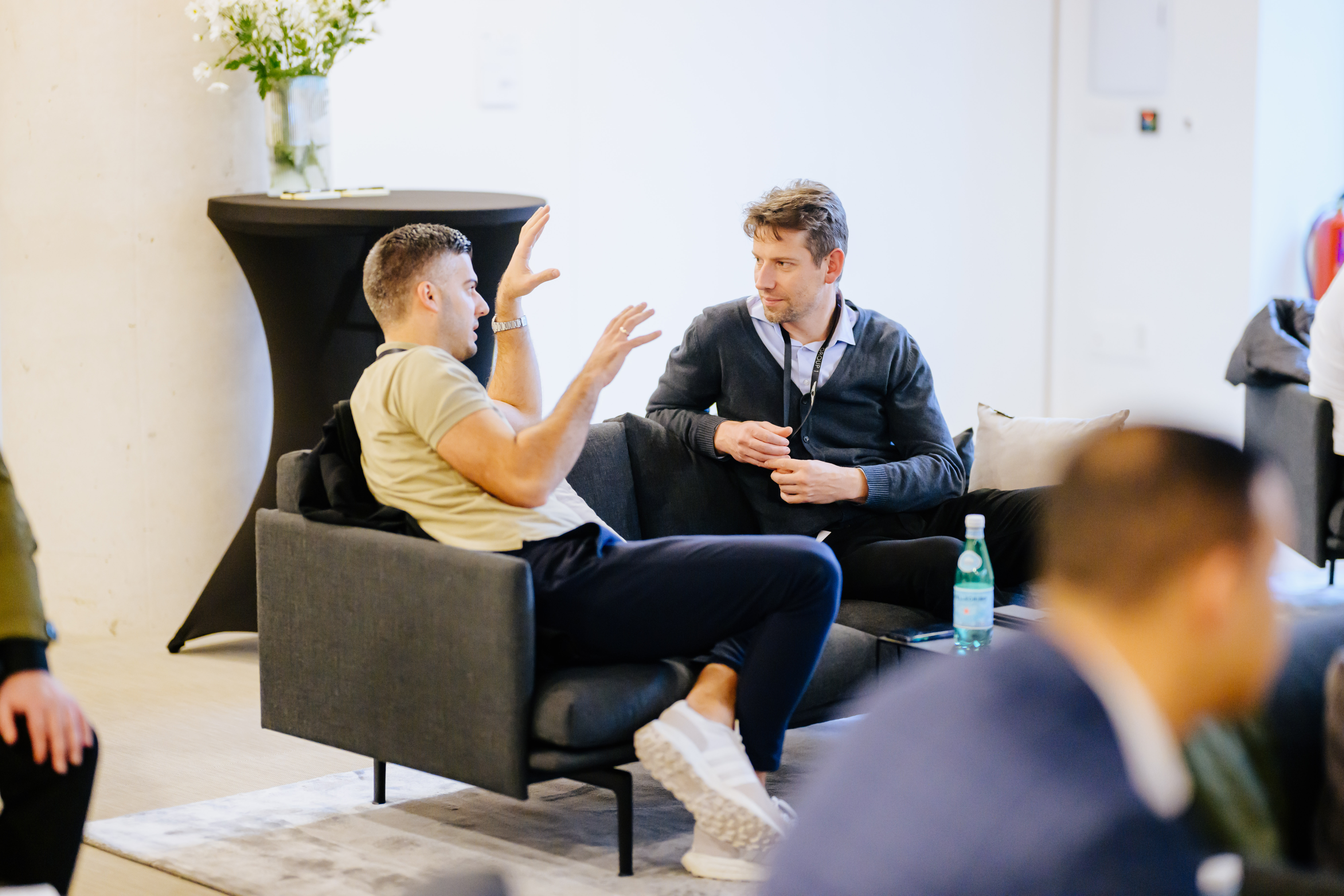 Intensives Zweiergespräch bei einer Automotive-Veranstaltung – Austausch über Produktstrategie oder Markenerlebnis im Lounge-Bereich.