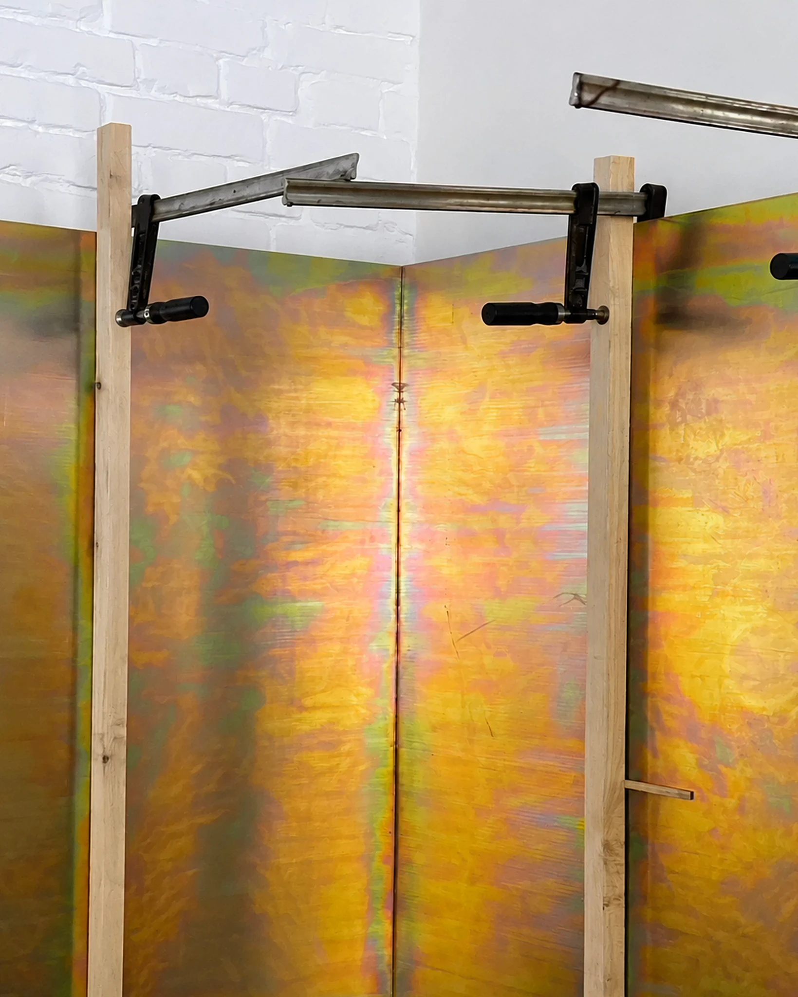 "Metal panels for 23A are temporarily fixed with clamps during the realization stage. The corner creates a soft mirrored effect, where two parts of the surface almost meet like two frames."