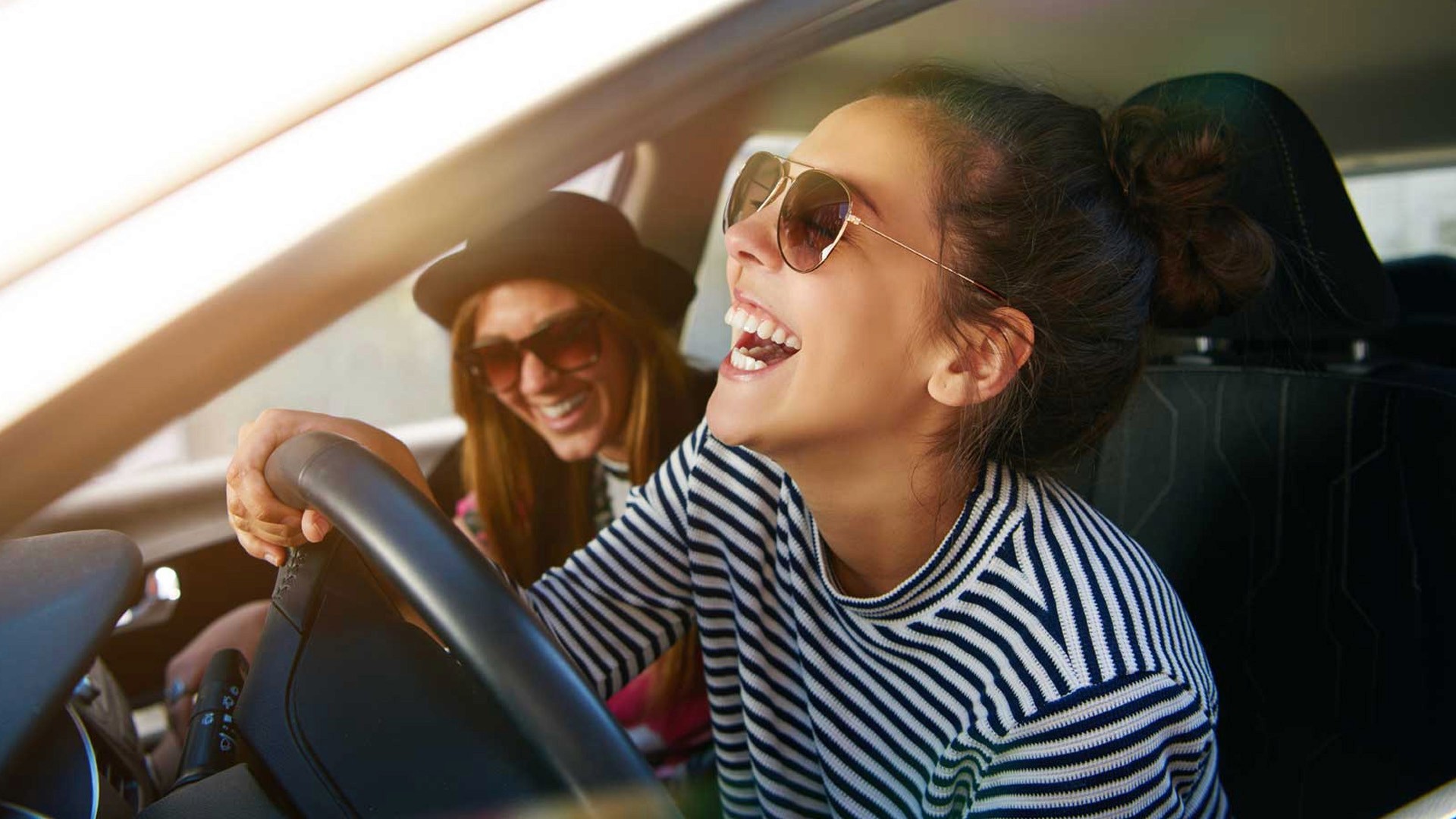 Młoda kobieta siedzi w samochodzie i skupia się na prowadzeniu.