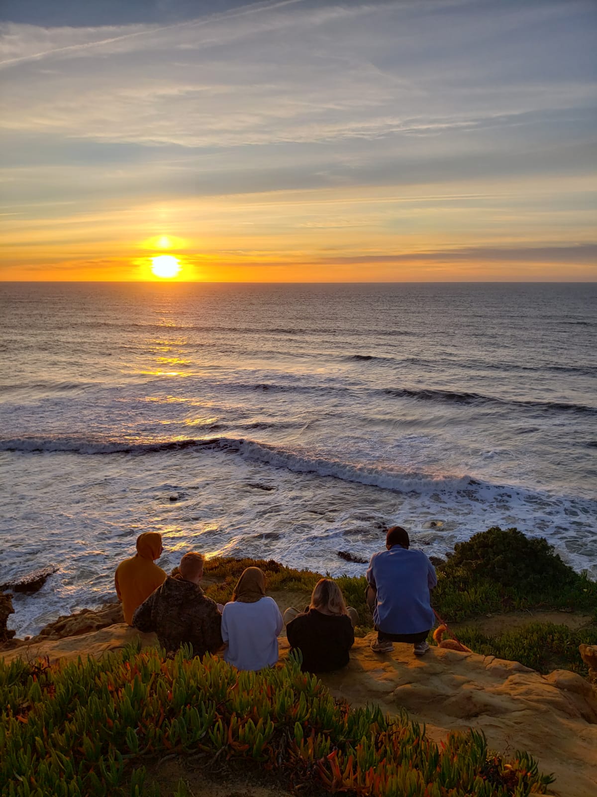 Group of digital nomads enjoying the sunset at Ericeira beach near Wild Souls