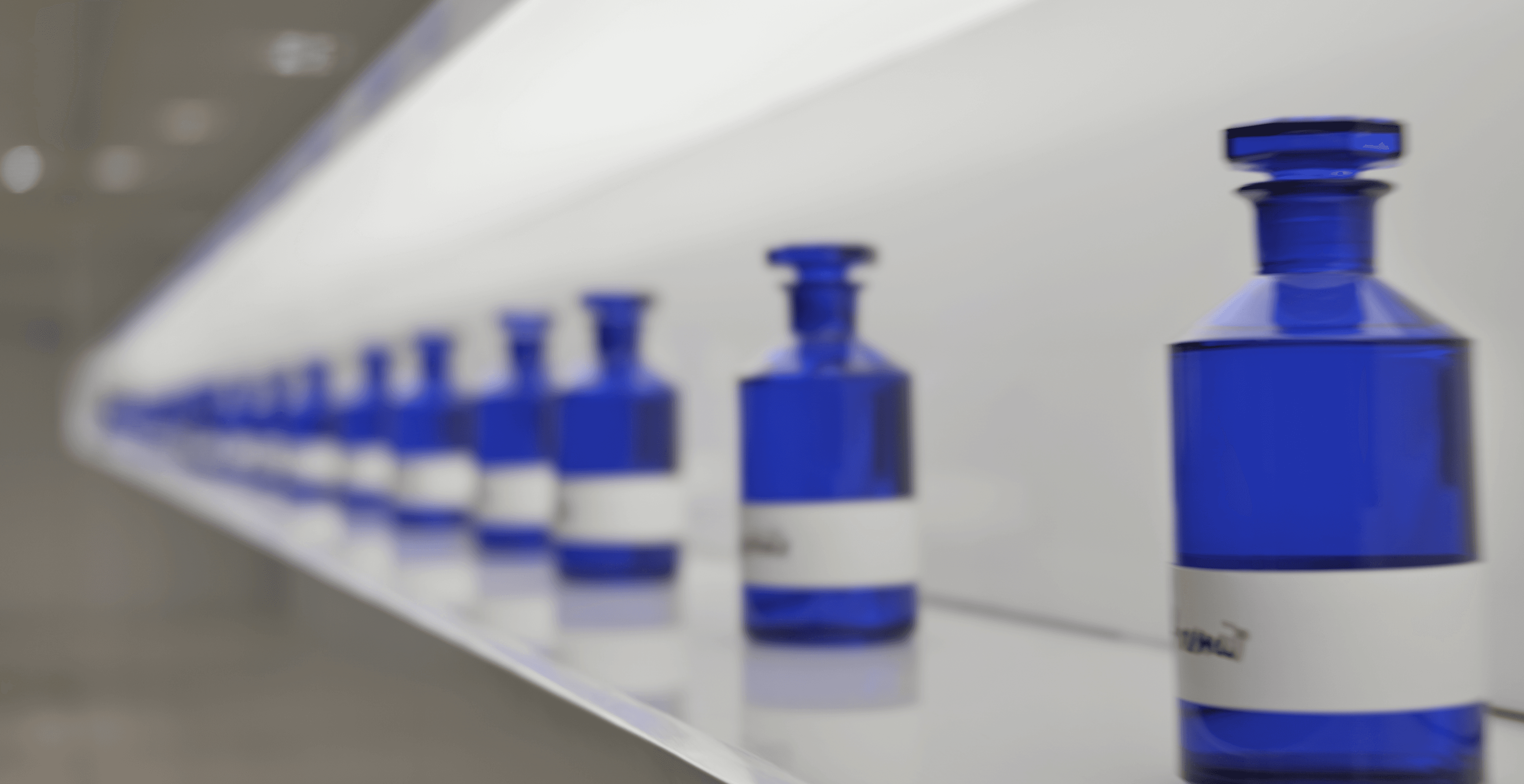 IFF Cobalt blue glass scent jars in a perspective row.