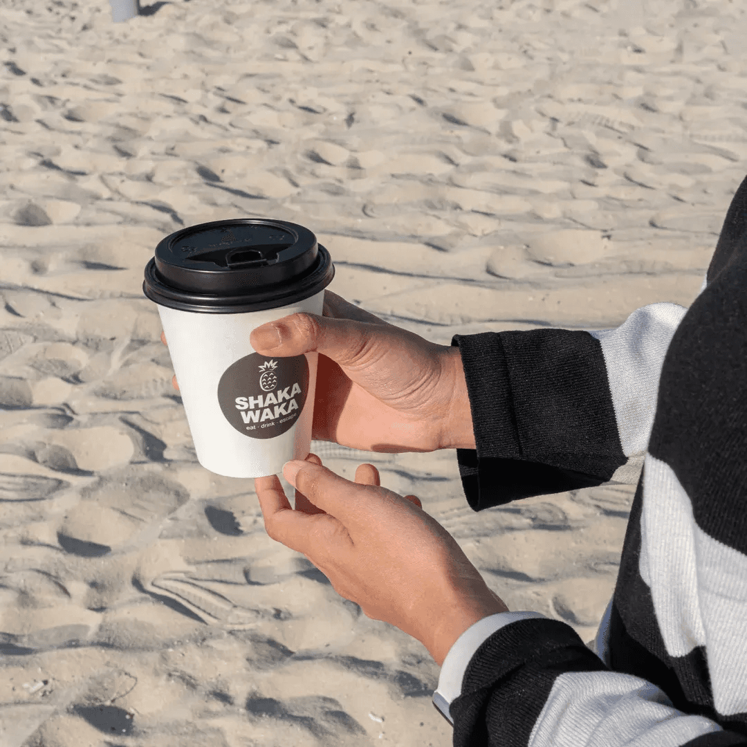 Branded takeaway cup representing a specialty coffee shop at Shaka Waka.
