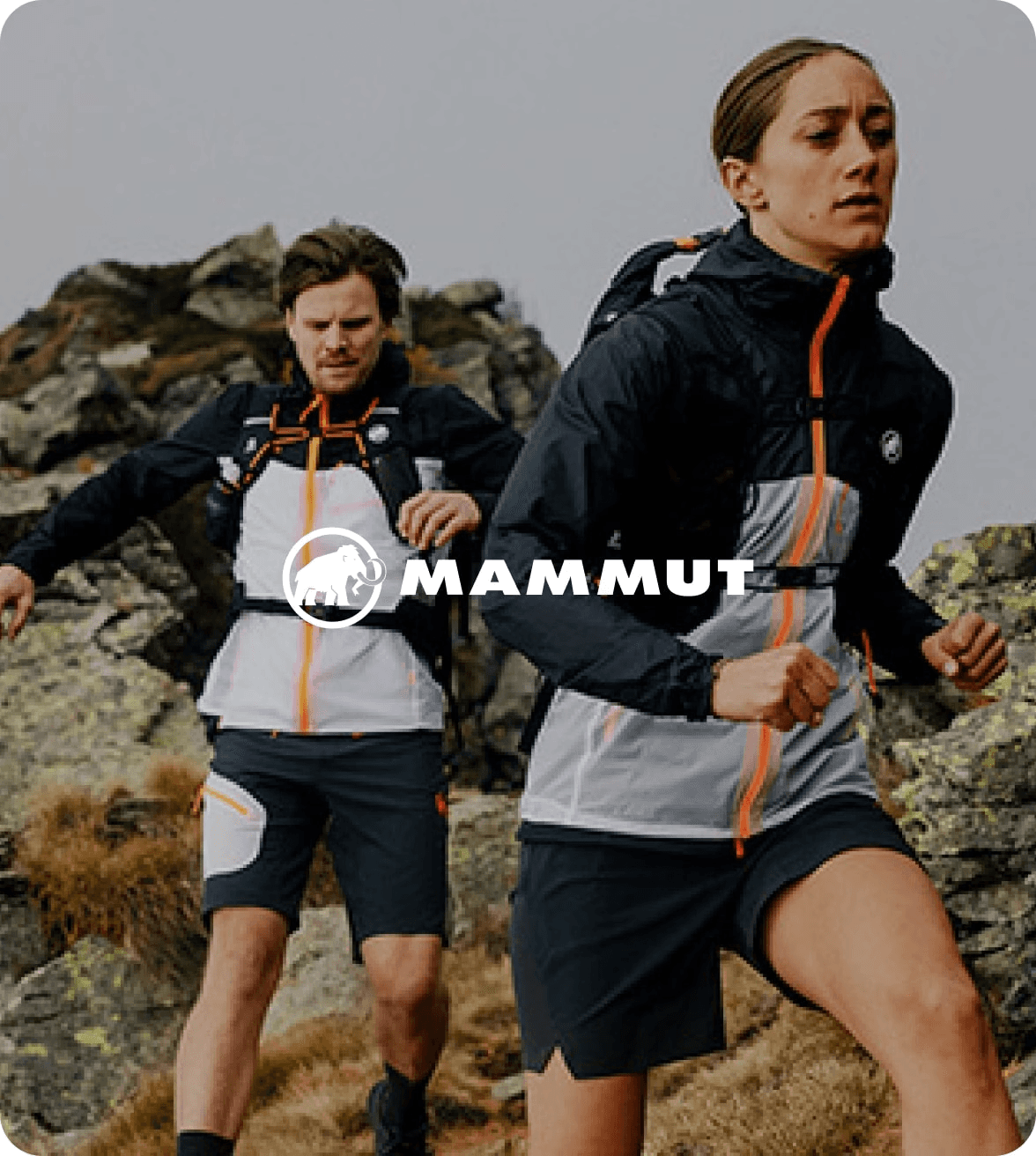 woman and man running on a mountain trail wearing mammut outdoor gear