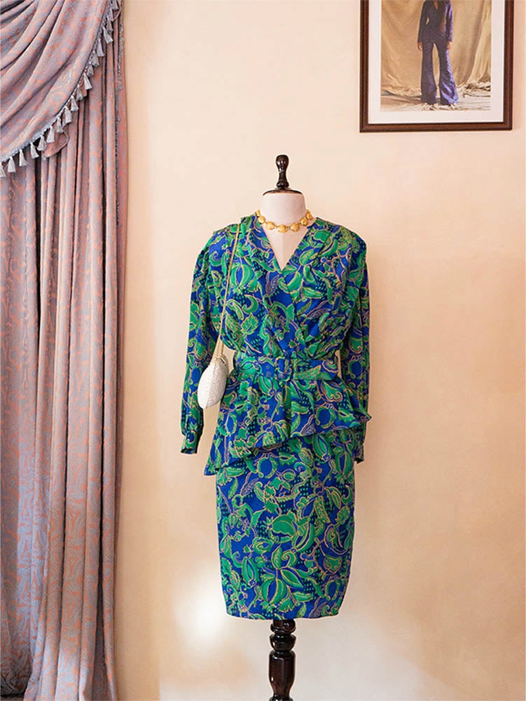 Vintage green and blue paisley print two-piece set with structured top and pencil skirt.
