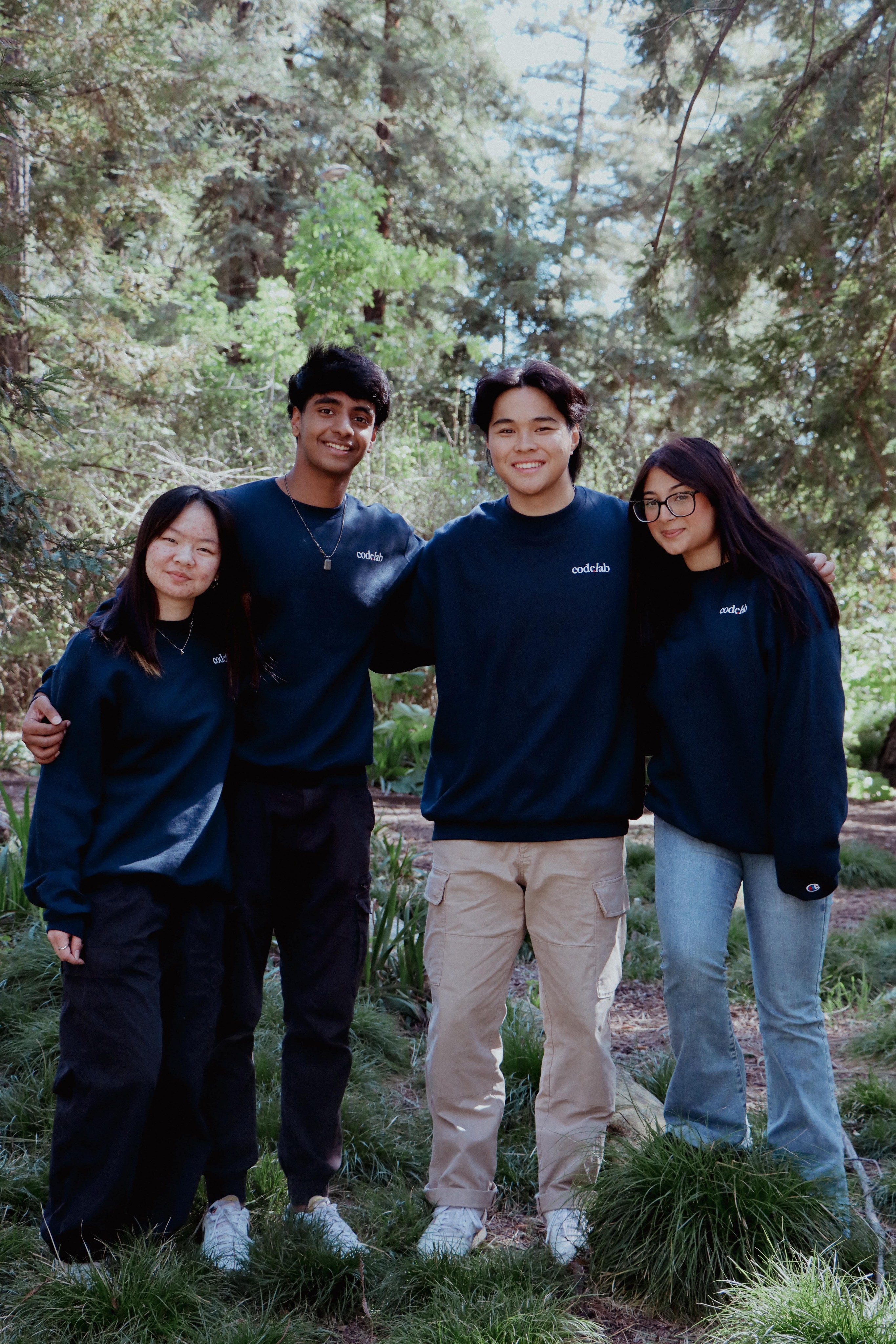 Picture of 4 people standing in the woods with matching CodeLab crewnecks