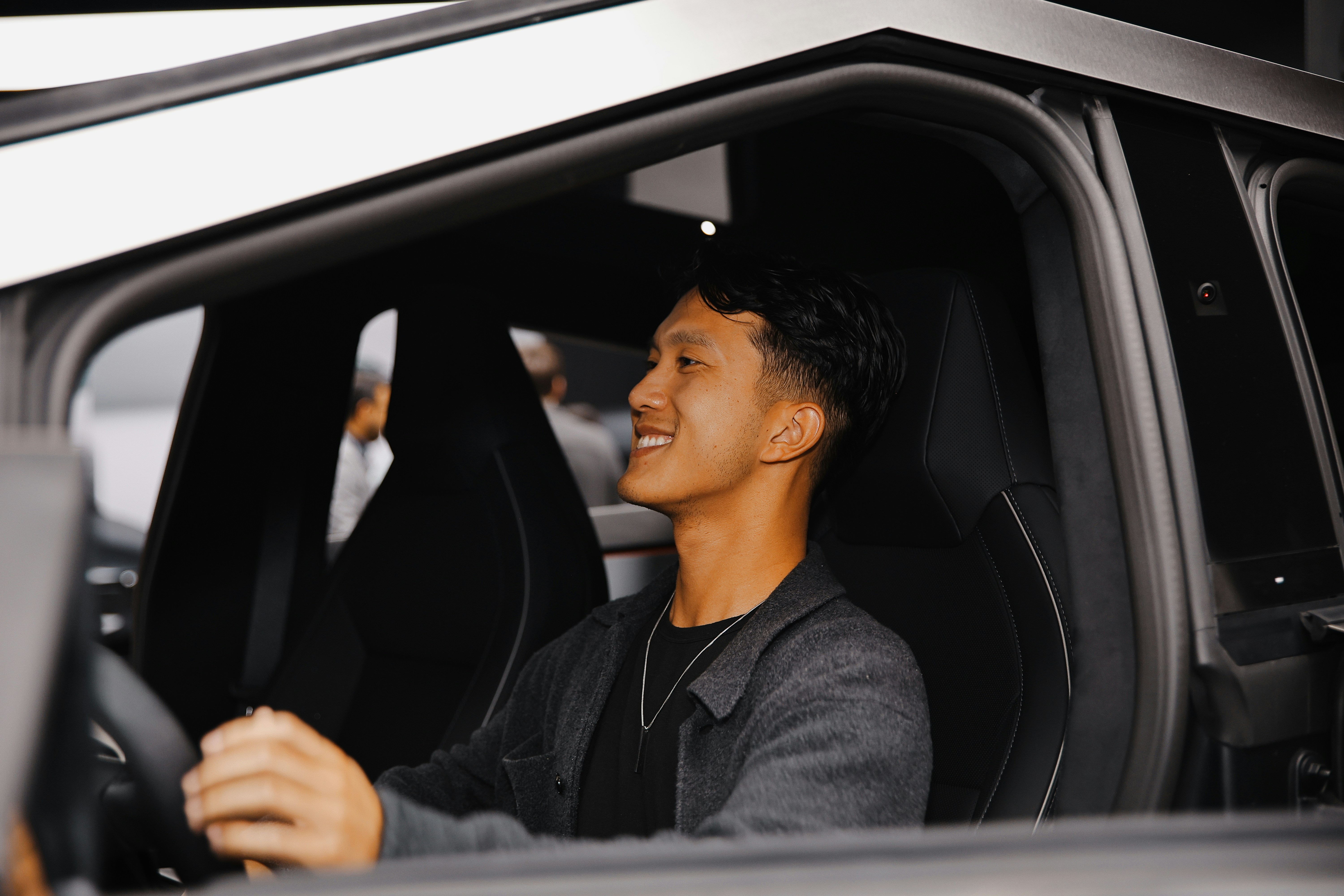 A young man sitting in a car with happy expression