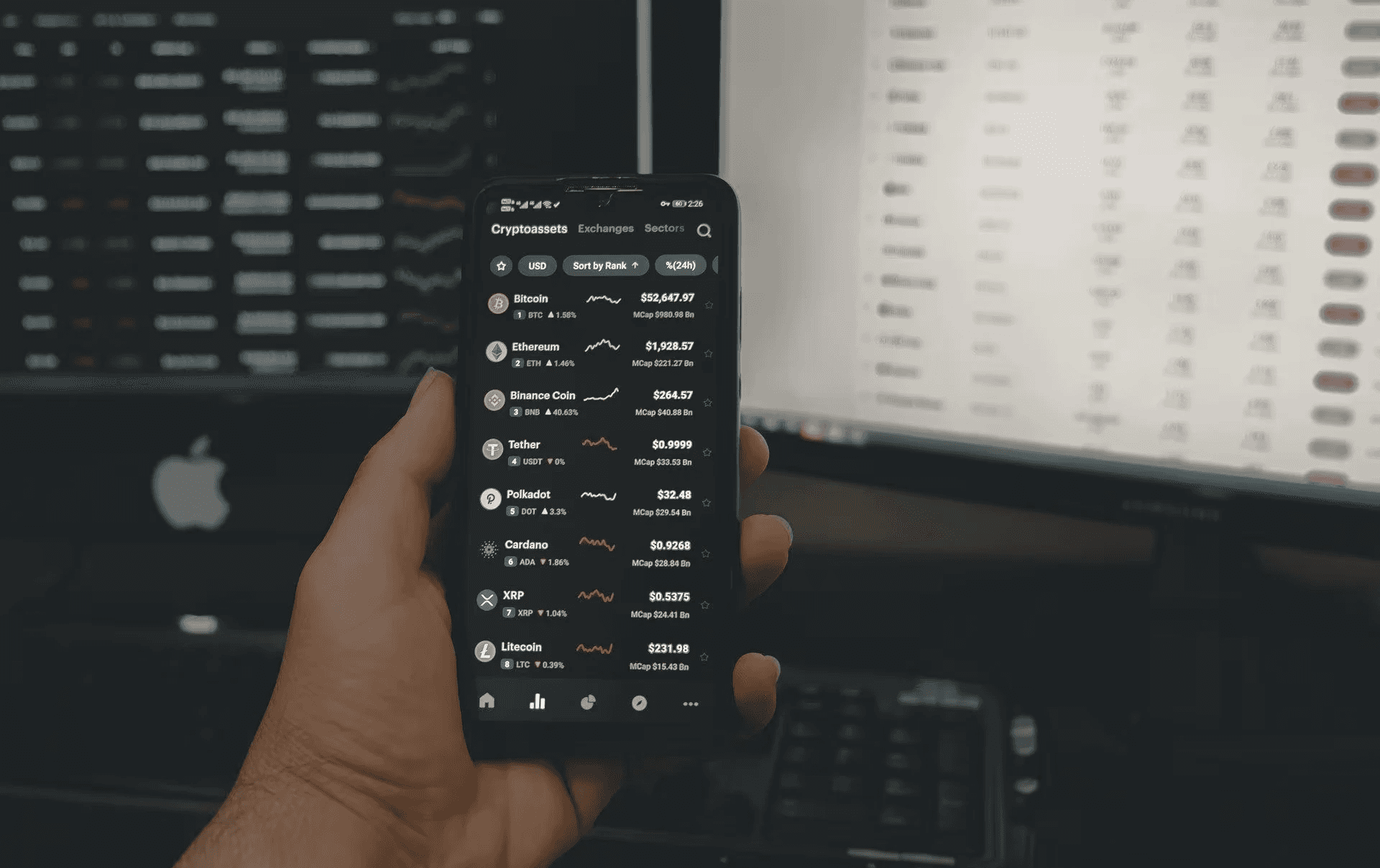 Person holding phone with crypto prices - What Is Floki Crypto