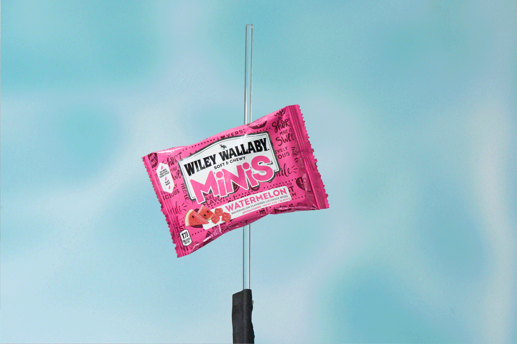 Wiley Wallaby Watermelon Minis candy pouch suspended on a stand against a blue backdrop