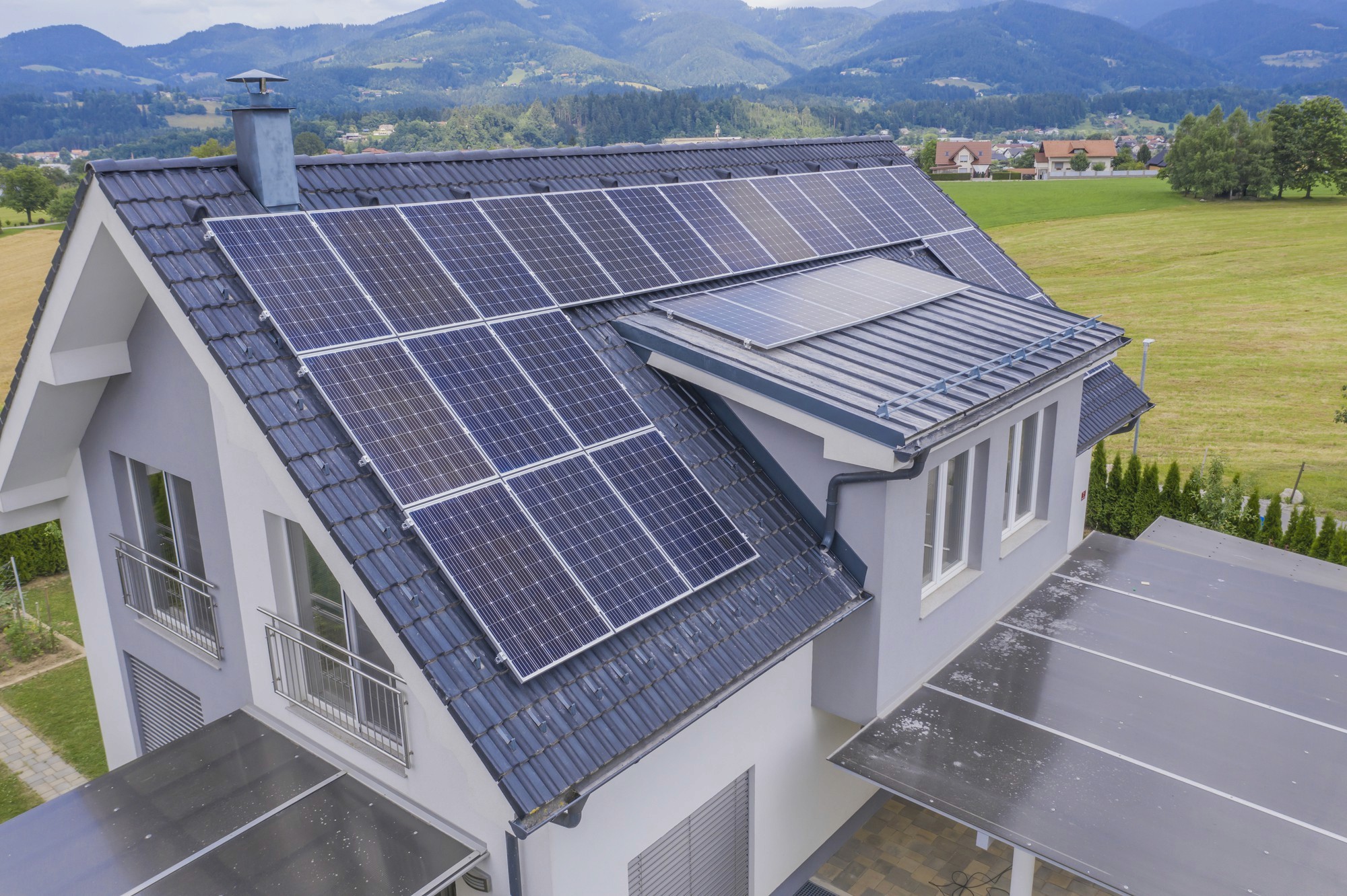 A rooftop view of a house with solar panels and energy-efficient windows.