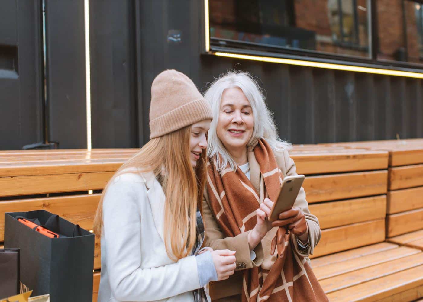 Older woman showing younger woman smartphone