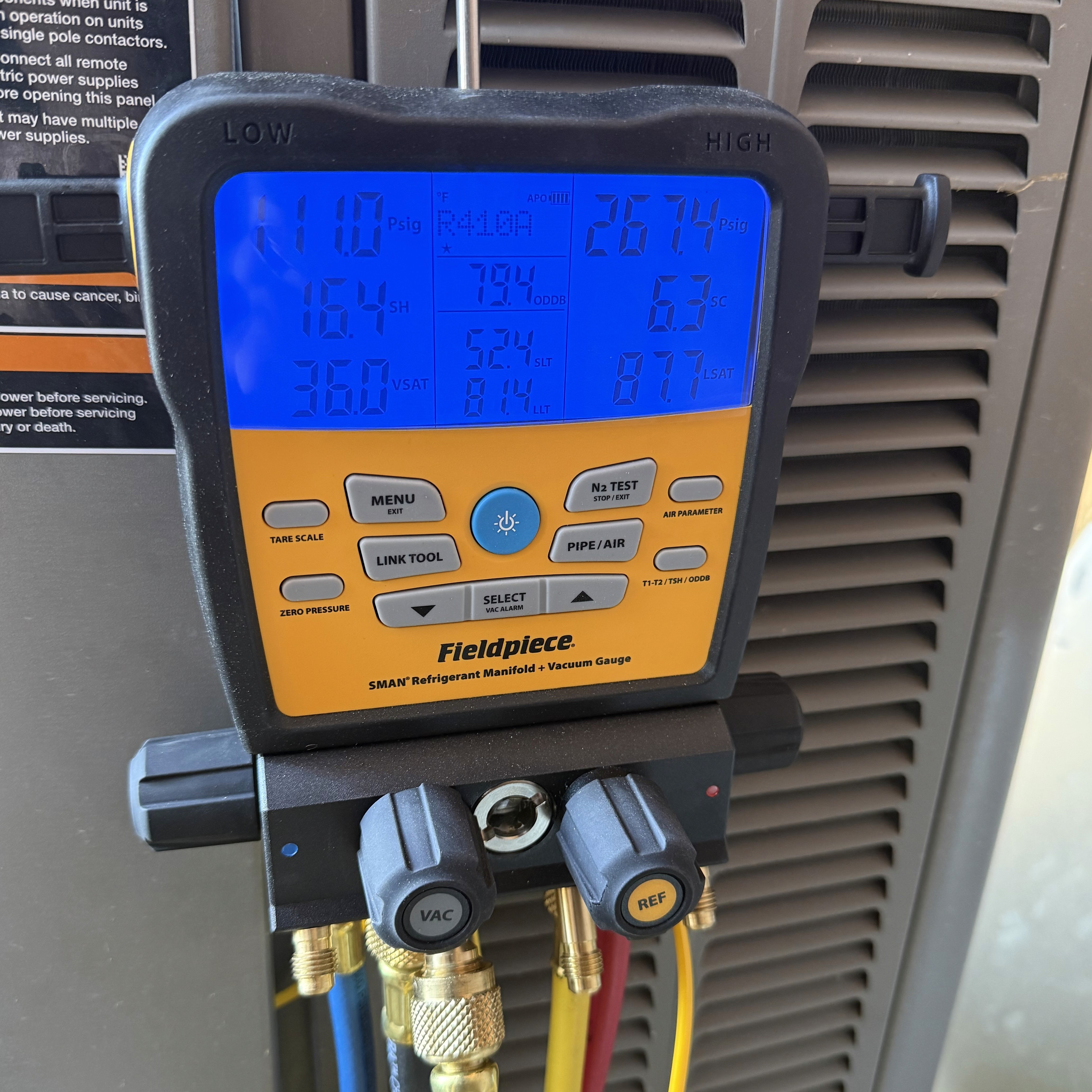 A Northstead technician measuring refrigerant pressures on a residential air conditioner with a digital manifold gauge in the Treasure Valley, Idaho.