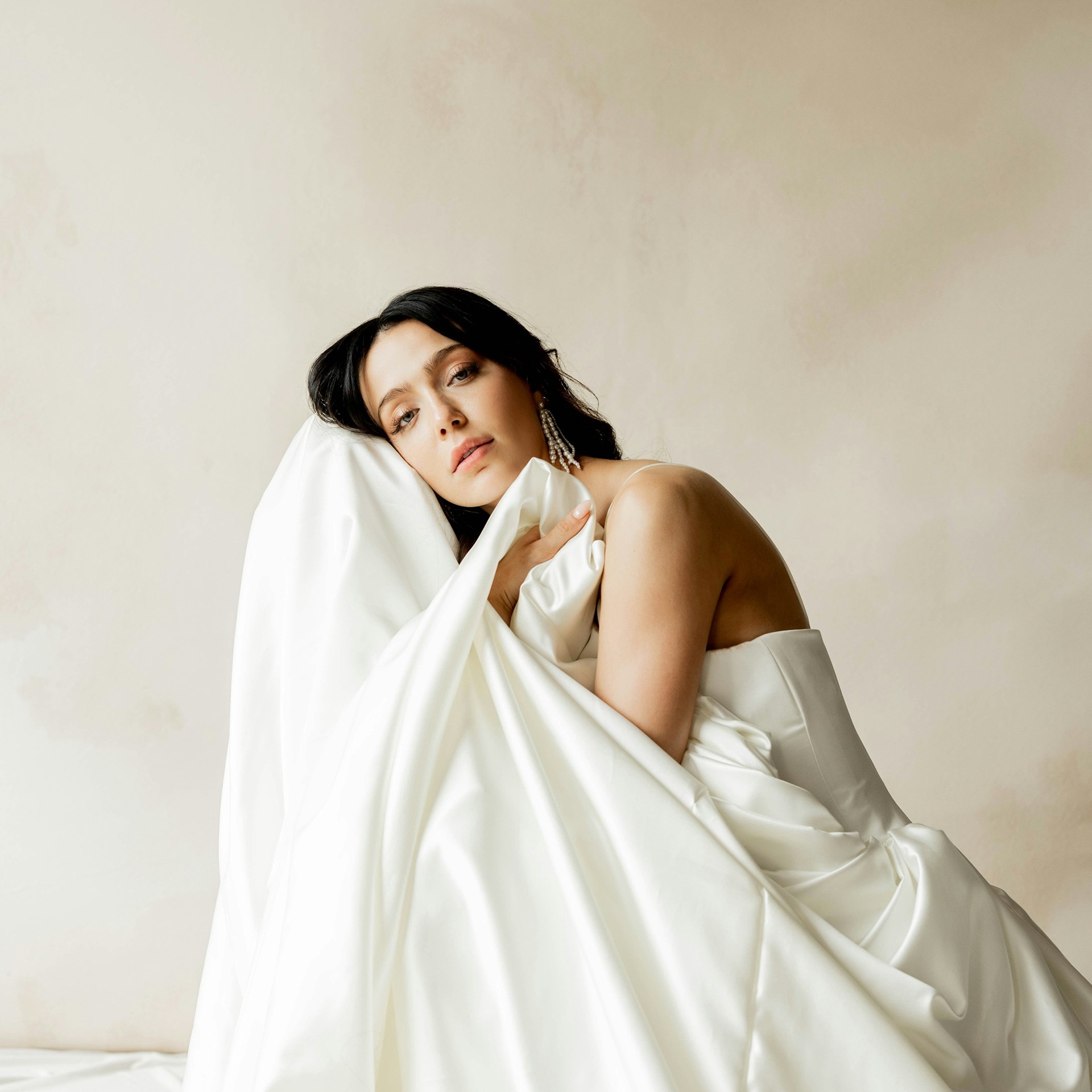 A woman poses in a light fabric dress