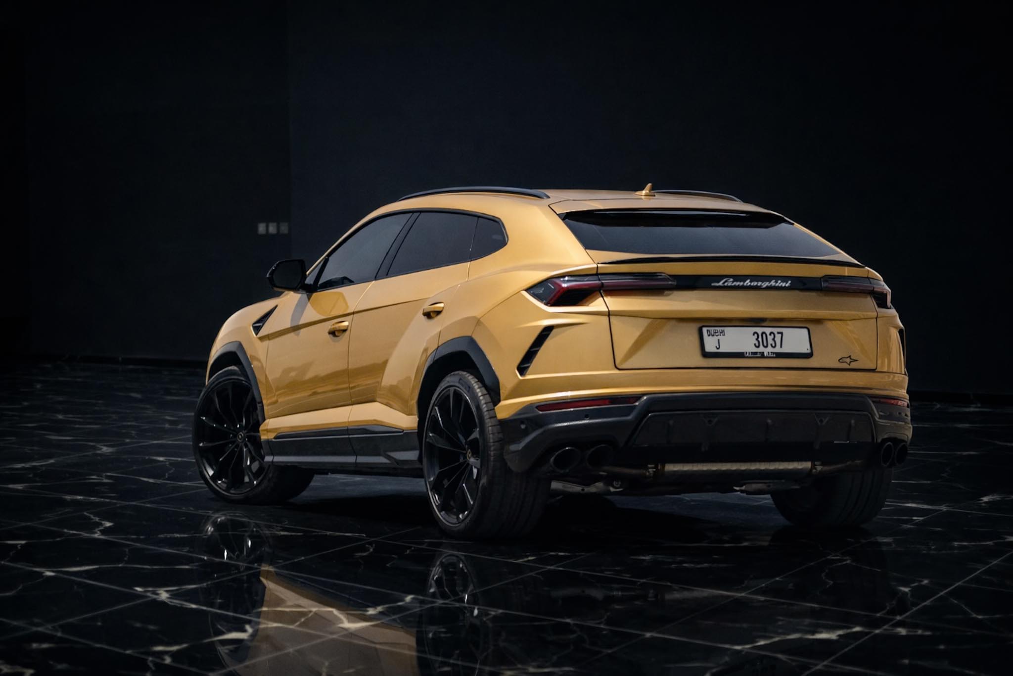 Gold Lamborghini Urus rear view luxury SUV rental Dubai