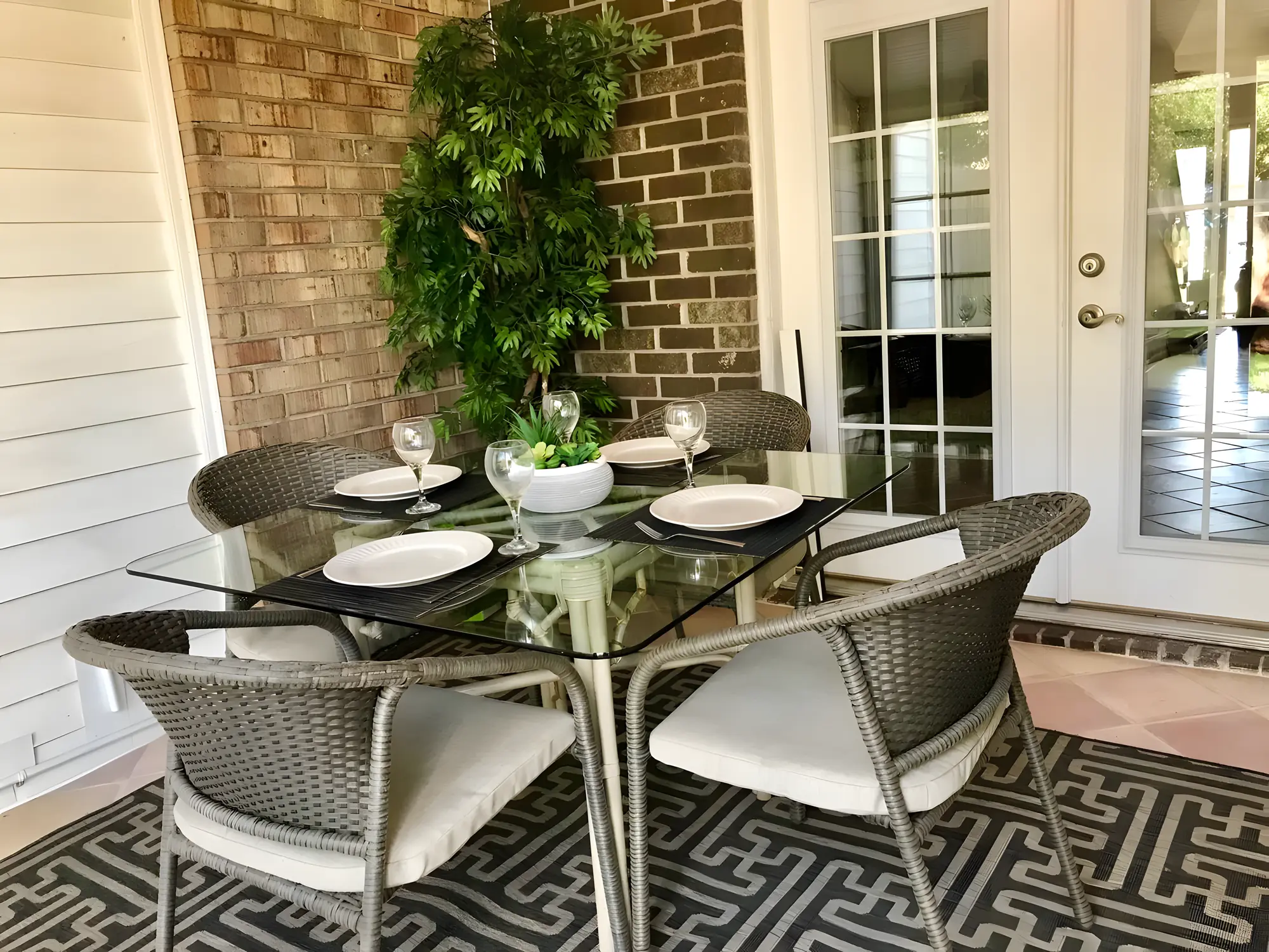 Glass dining table set for four on the screened porch