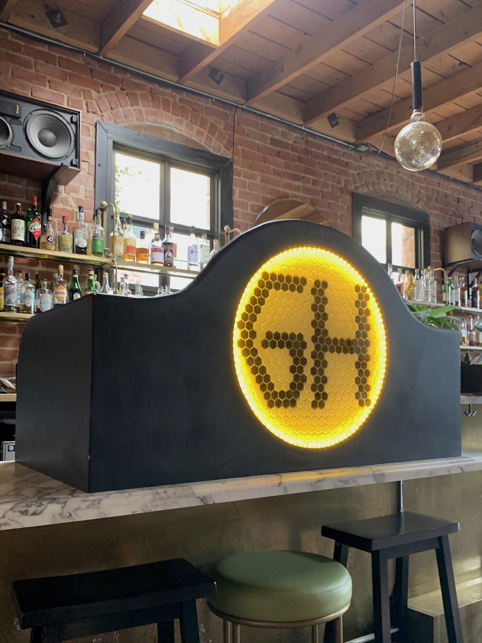 Black bar fixture with an illuminated yellow honeycomb panel