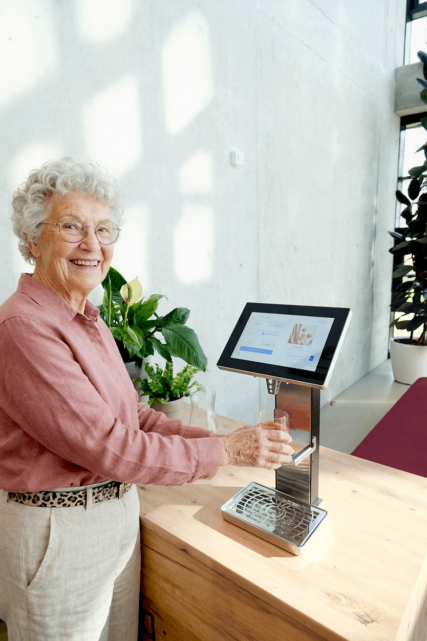 Seniorin trinkt personalisiertes Re:Drink Getränk – Dehydratationsprophylaxe in der stationären Pflege.