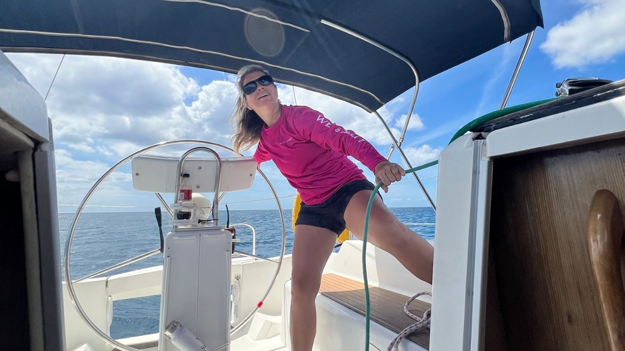 A woman sailing a sailboat single-handedly