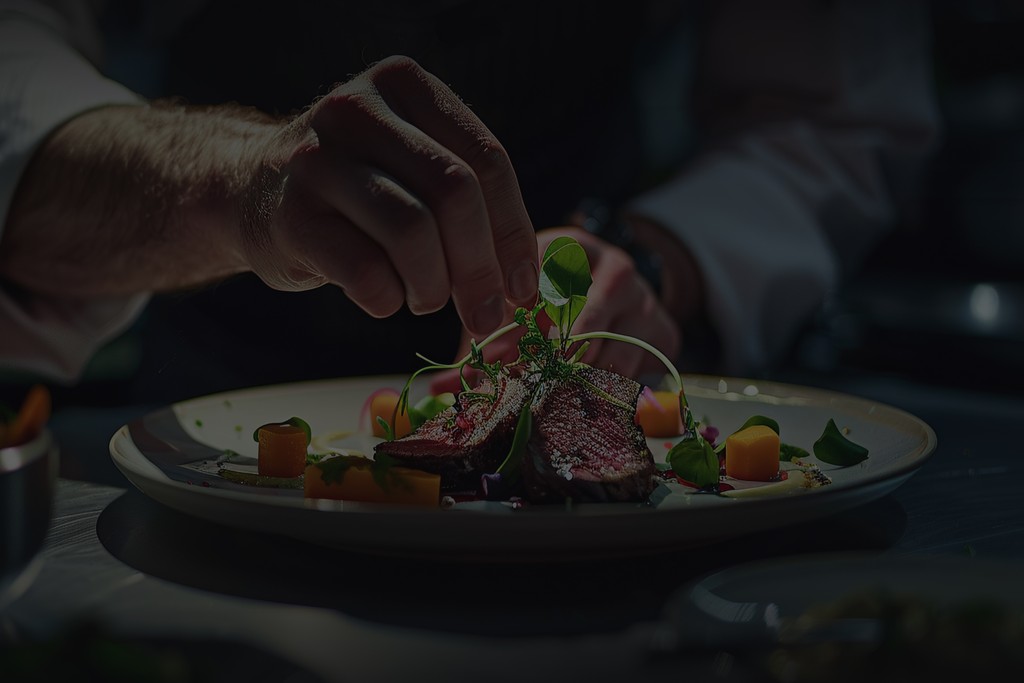 Chef Norman Van Aken plating a dish