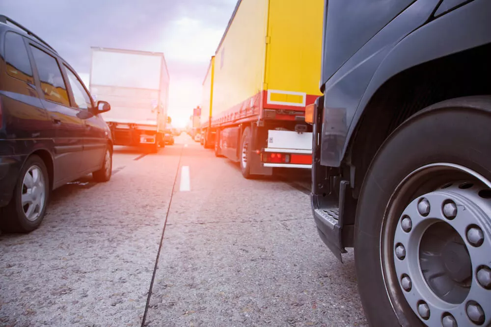 Cars and trucks stuck in traffic on a highway at sunset