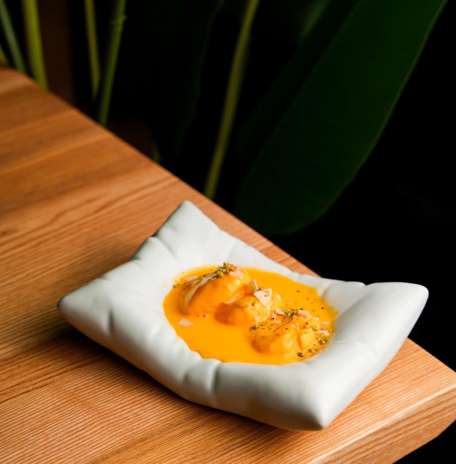 Mango rasmalai dessert at Dhoom in Greektown Toronto, soft cheese dumplings soaked in mango-infused milk