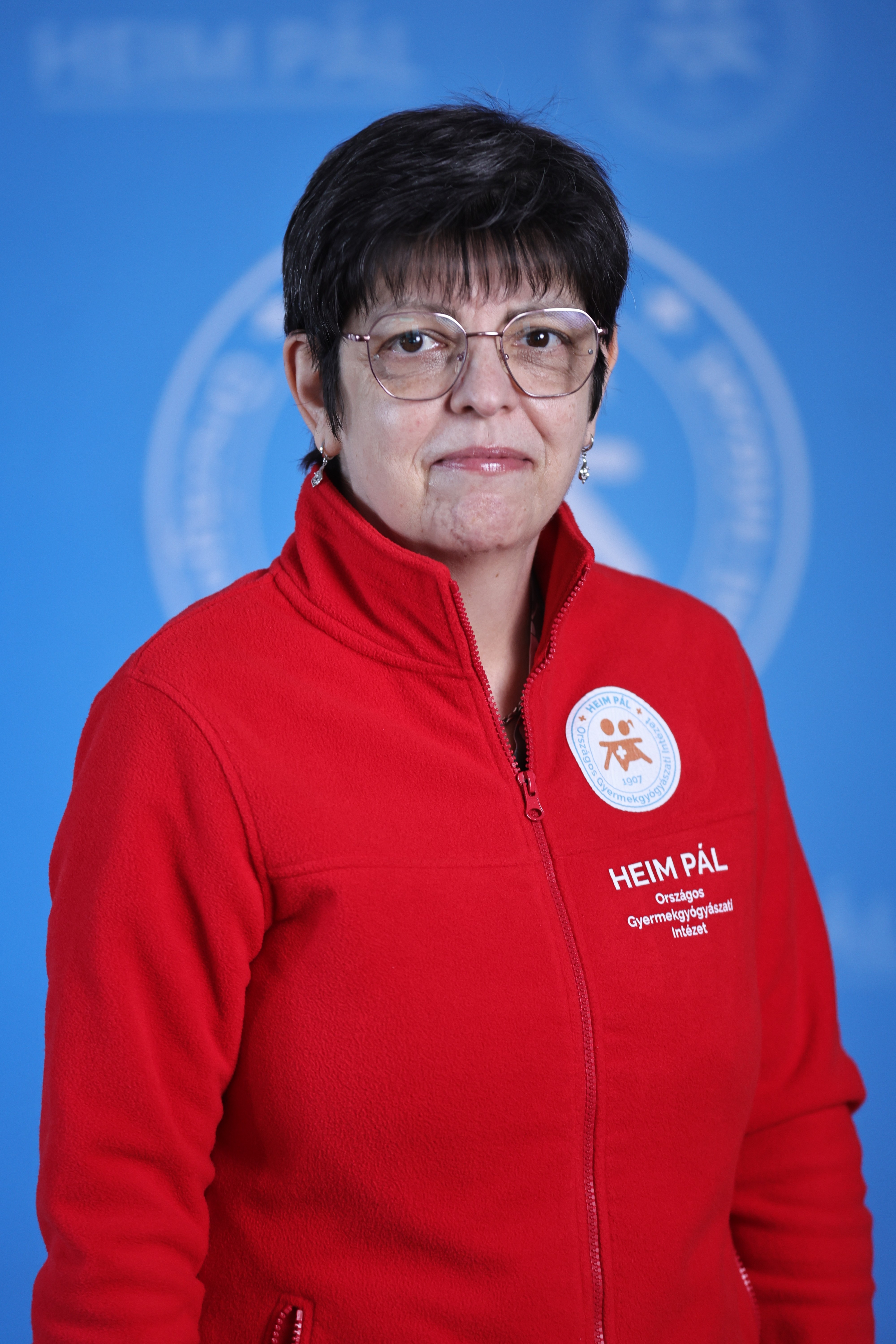 Fekete rövidhajú orvosnő piros kardigánban