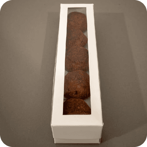 Caja blanca cerrada con ventana transparente mostrando mini brownies.