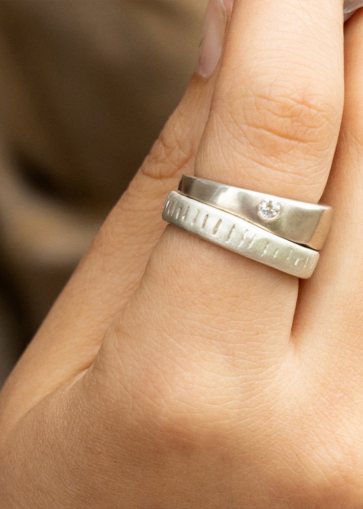 Silver ring on a person's finger against a blurred background