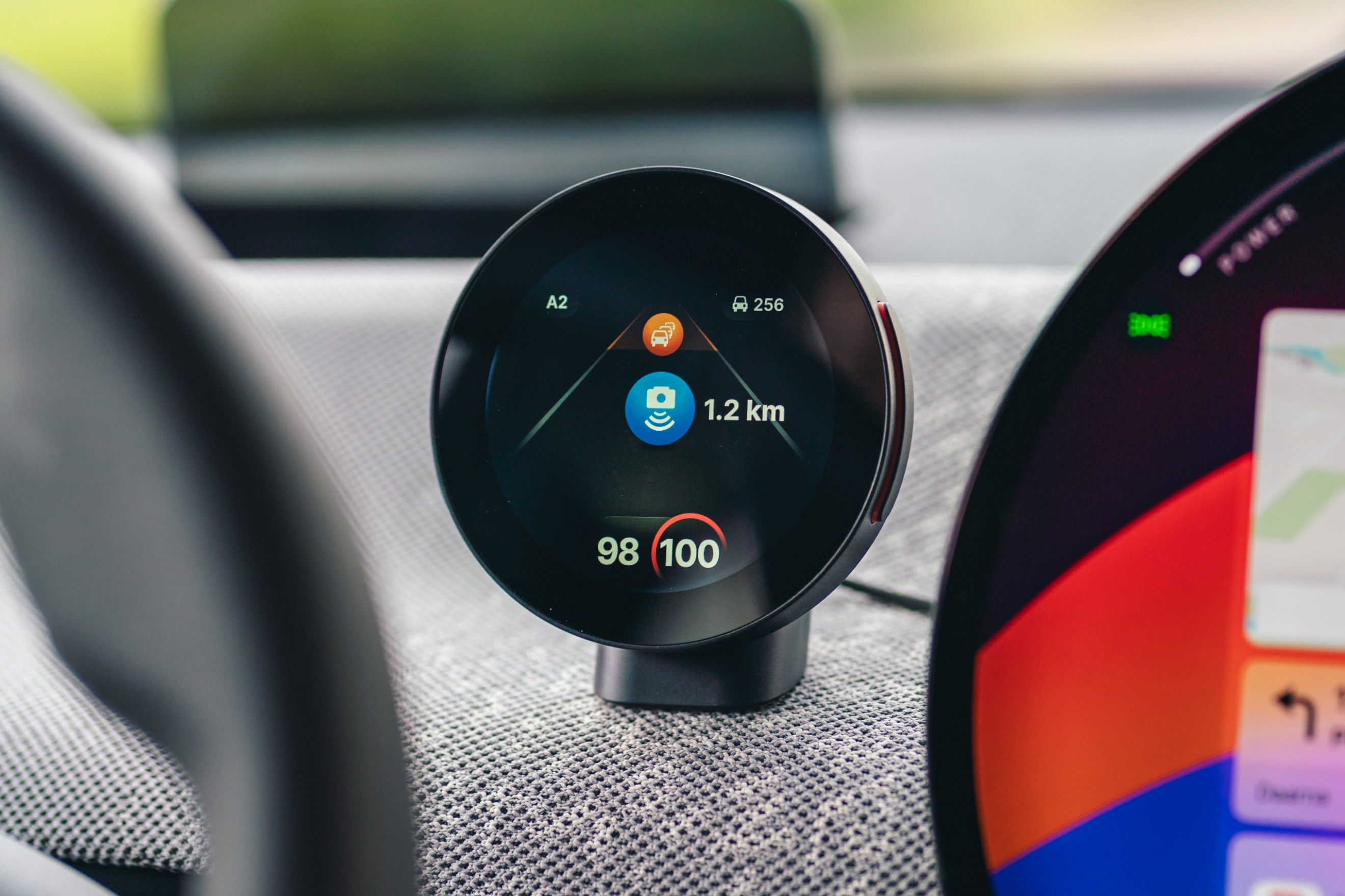 Flitsmeister DASH displayed on the dashboard of a new Mini Cooper SE interior, highlighting the speedtrap warning feature. The digital screen shows a clear alert of an upcoming speedtrap, integrated smoothly into the modern car's infotainment system.